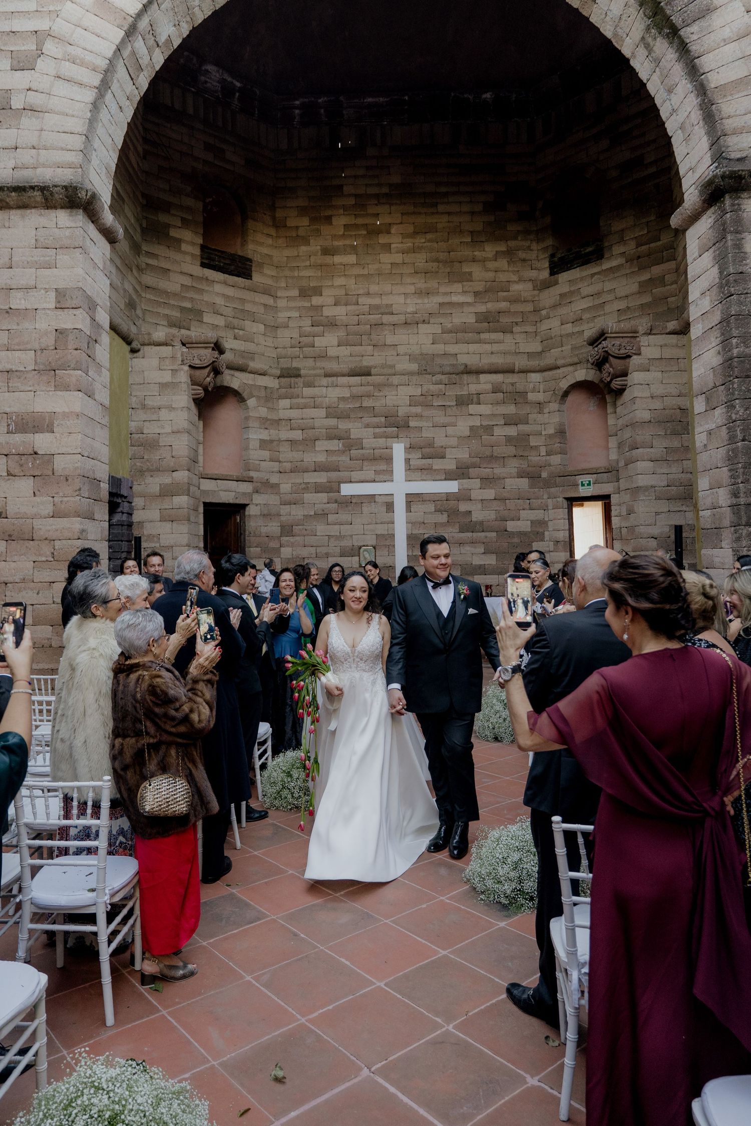 Wedding celebration in a rustic stone courtyard with guests mingling after the ceremony.