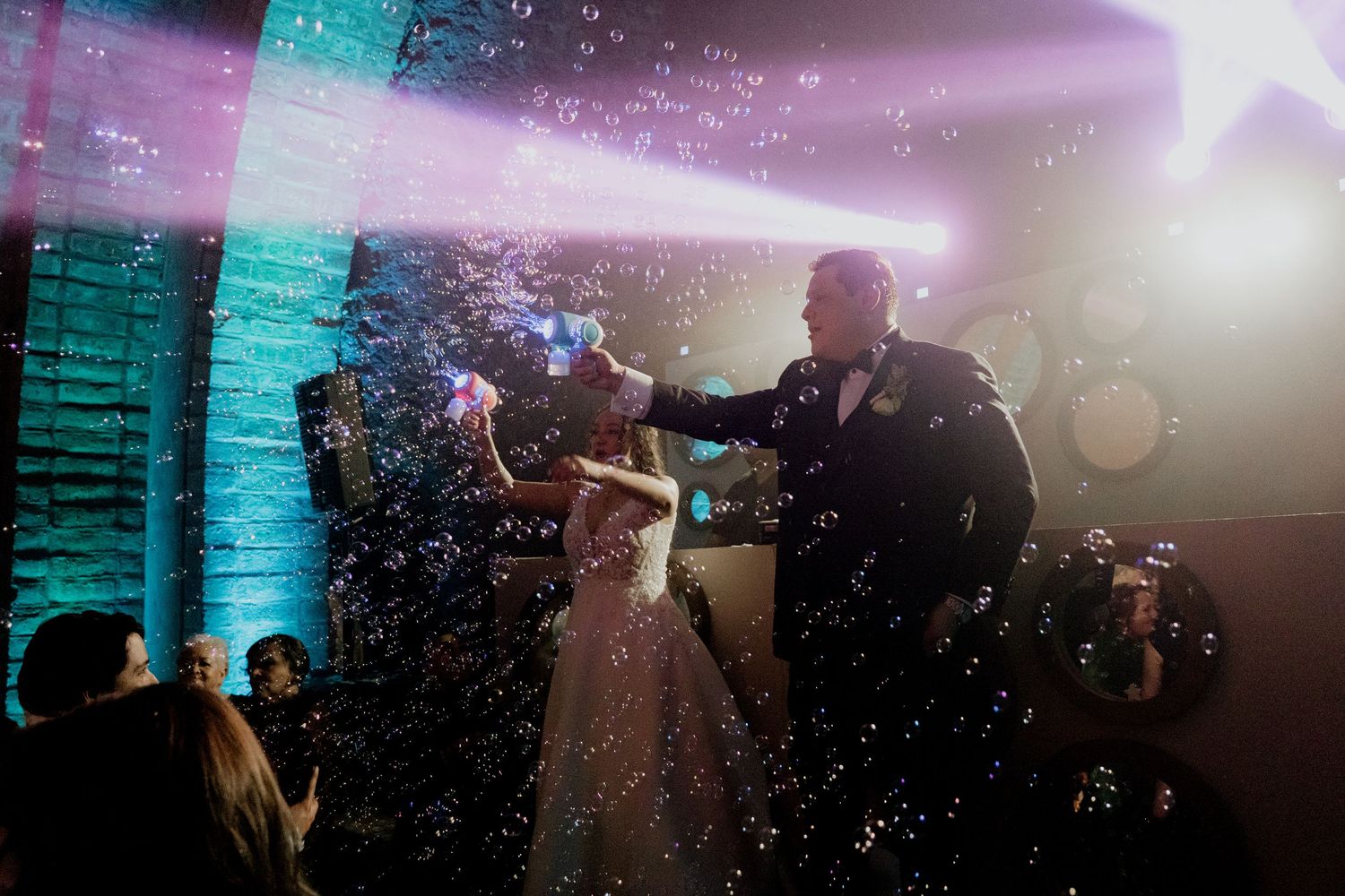 Wedding reception dance floor with colorful lighting and bubble effects creating a magical atmosphere.