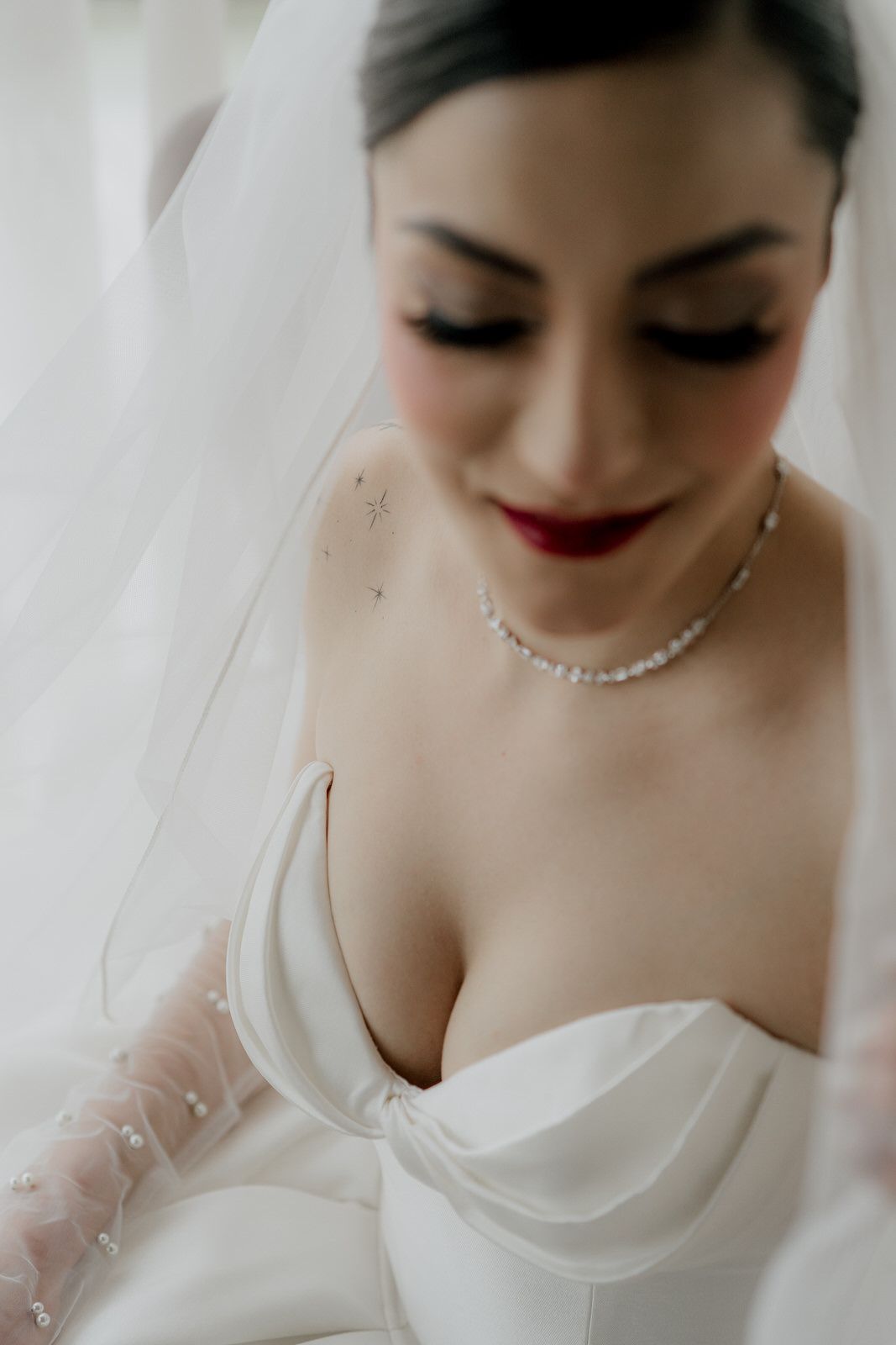 Intimate bridal portrait featuring classic makeup and sparkling necklace with strapless gown.