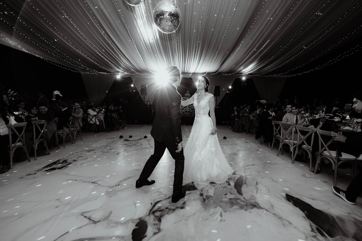 Wedding dance floor illuminated by disco ball and special effects creating a magical atmosphere.