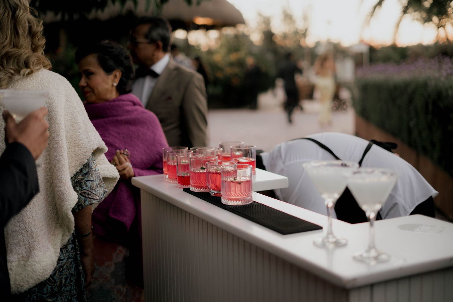 Wedding reception bar setup with red drinks on display.