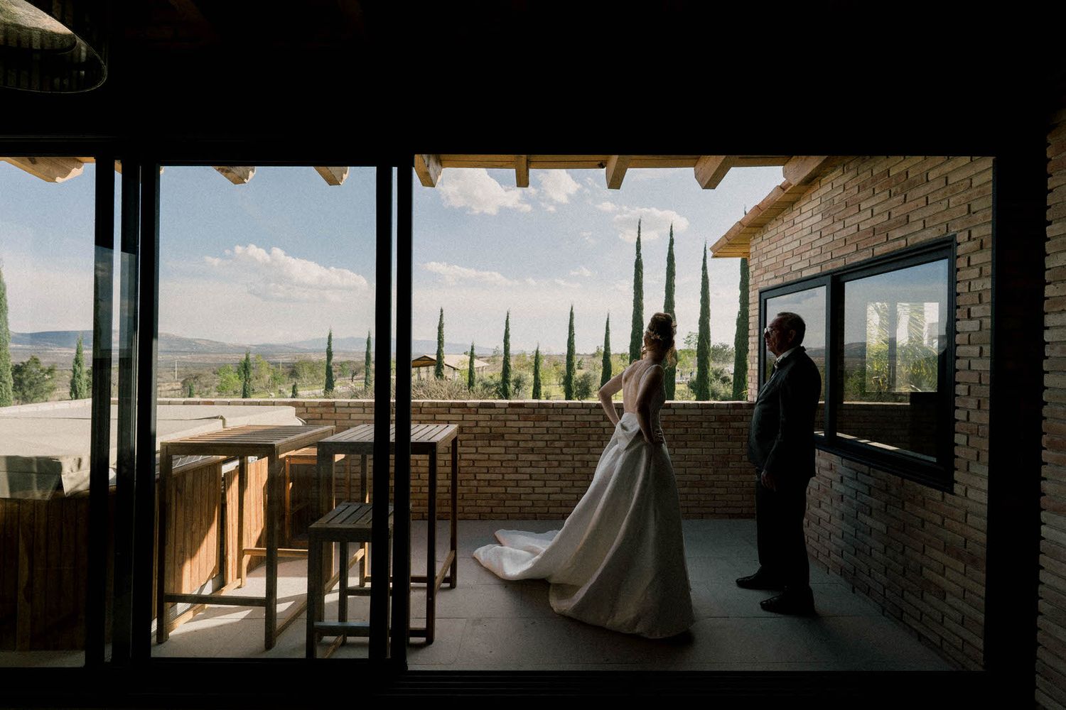Modern building interior with panoramic windows and silhouetted figures.