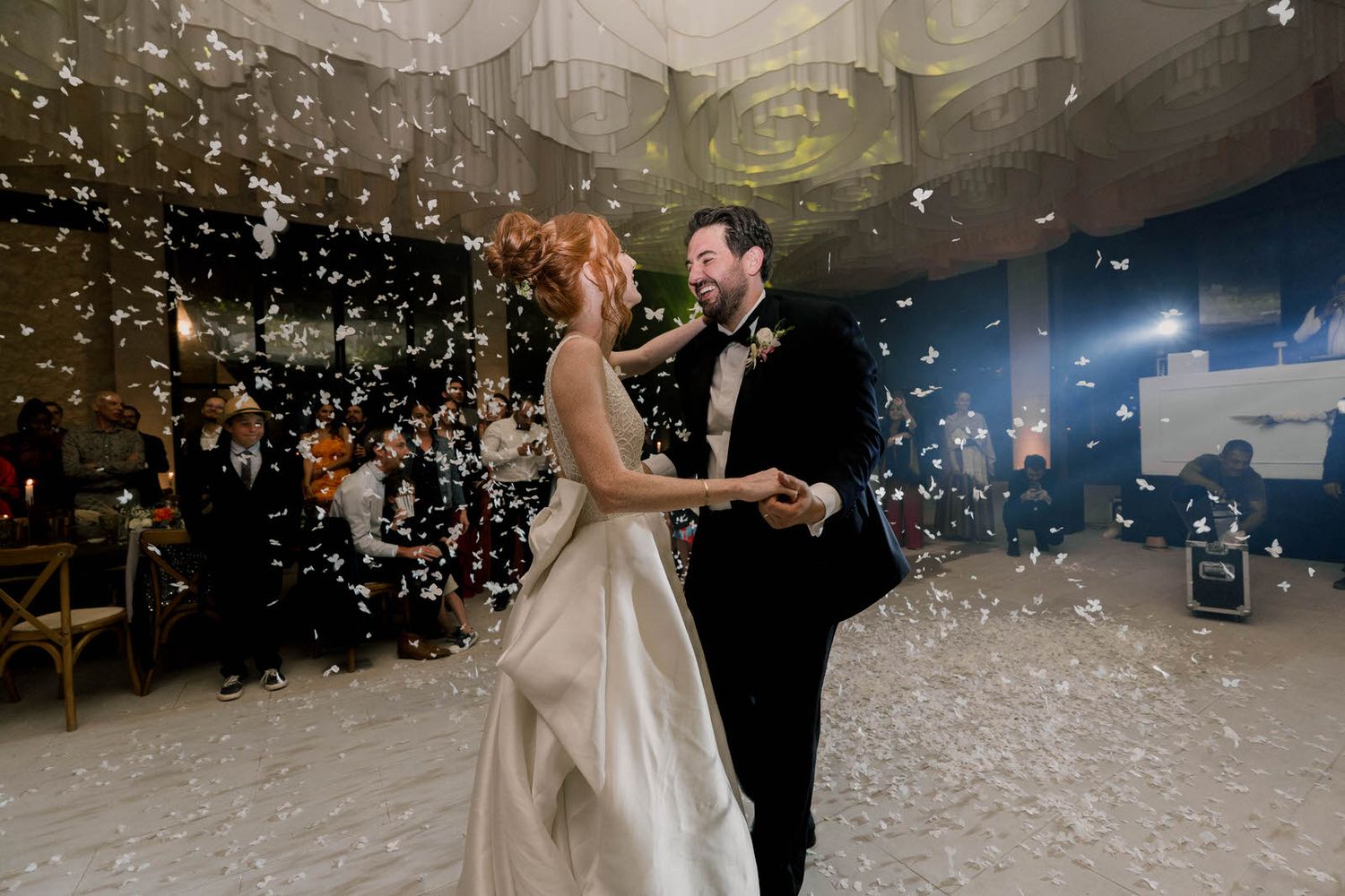 Snowlike confetti creates a dreamy atmosphere during an elegant wedding dance.