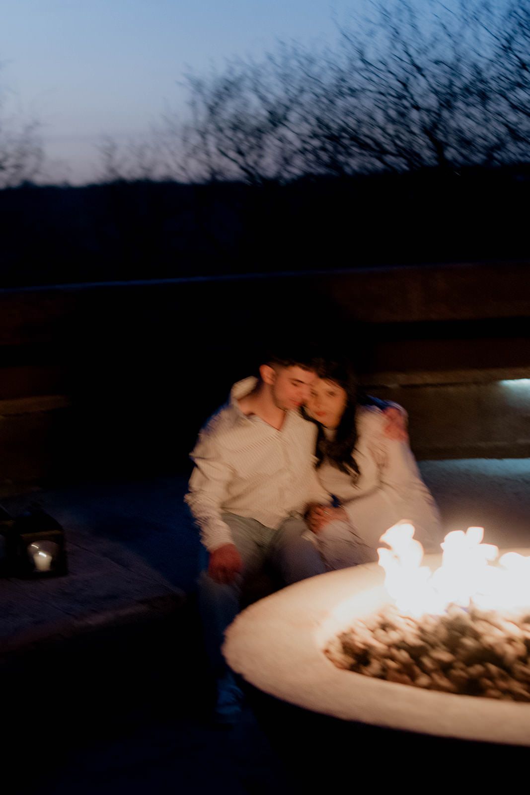 Cozy moment by glowing fire pit during twilight hours.