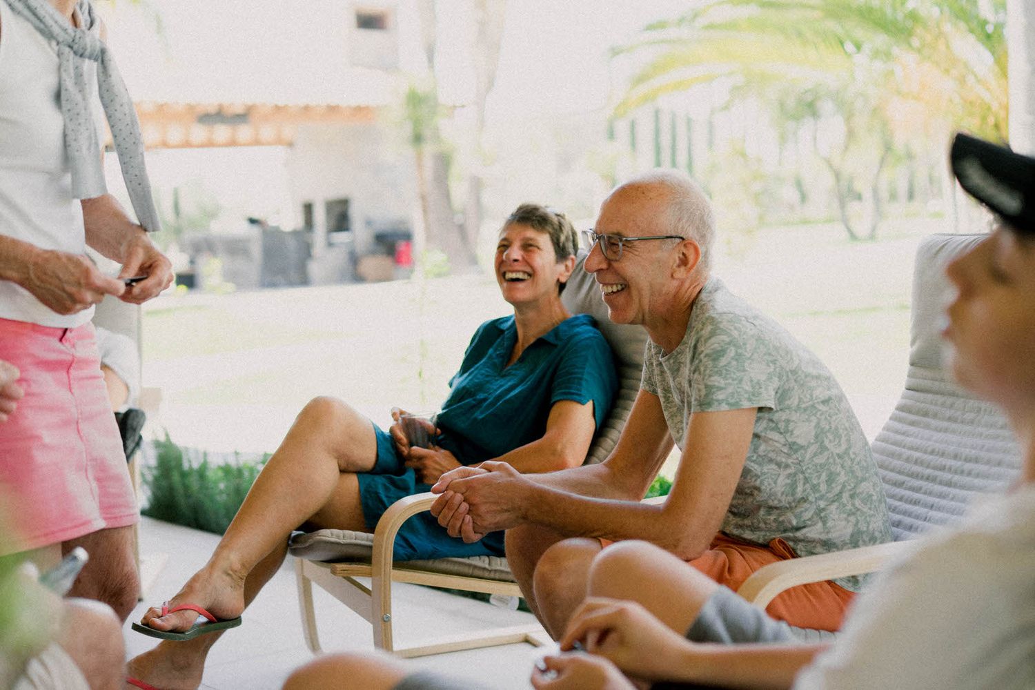 Outdoor patio area with people gathered in casual conversation during a daytime event.
