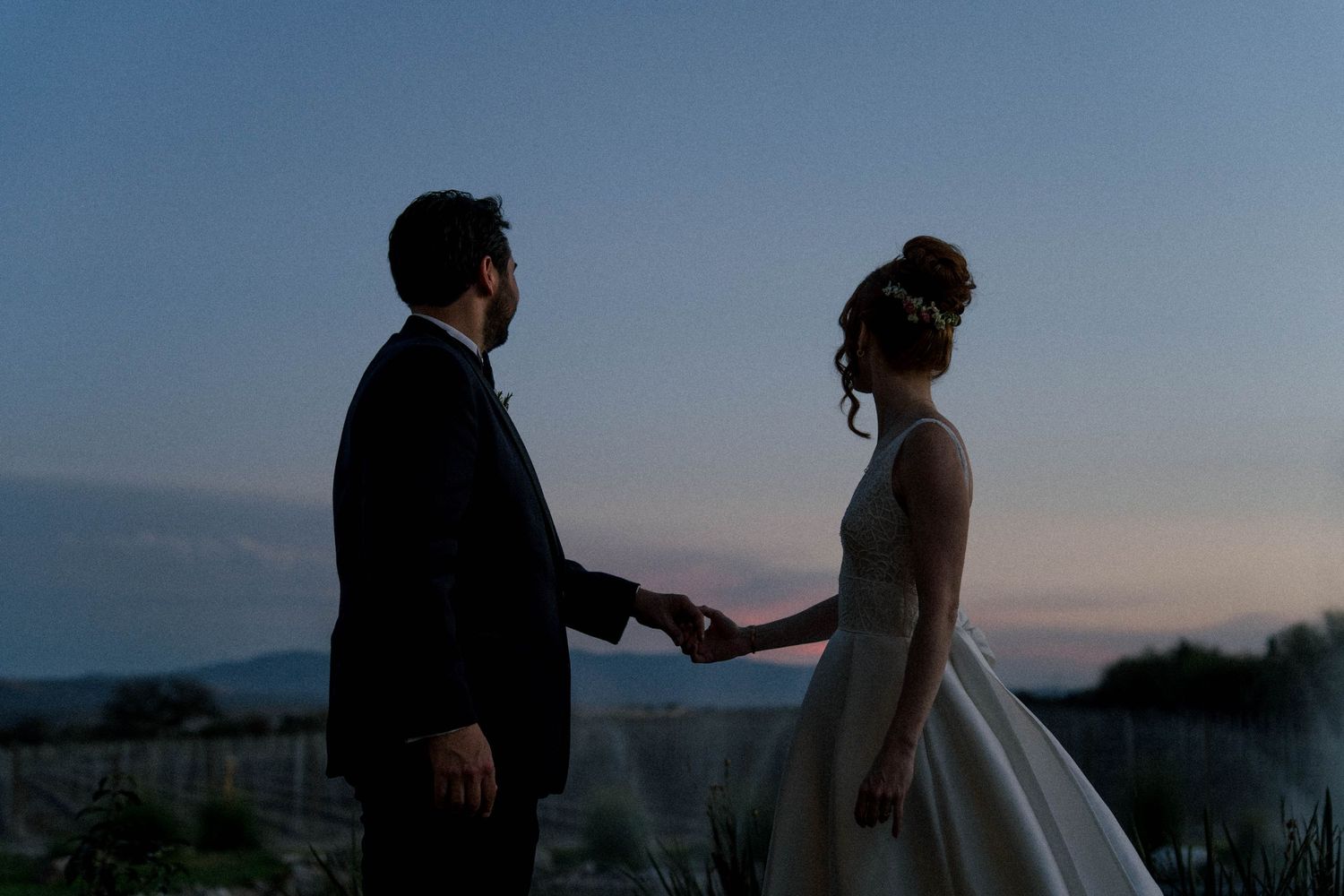 Silhouetted couple shares an intimate moment against a dramatic sunset sky on the beach.