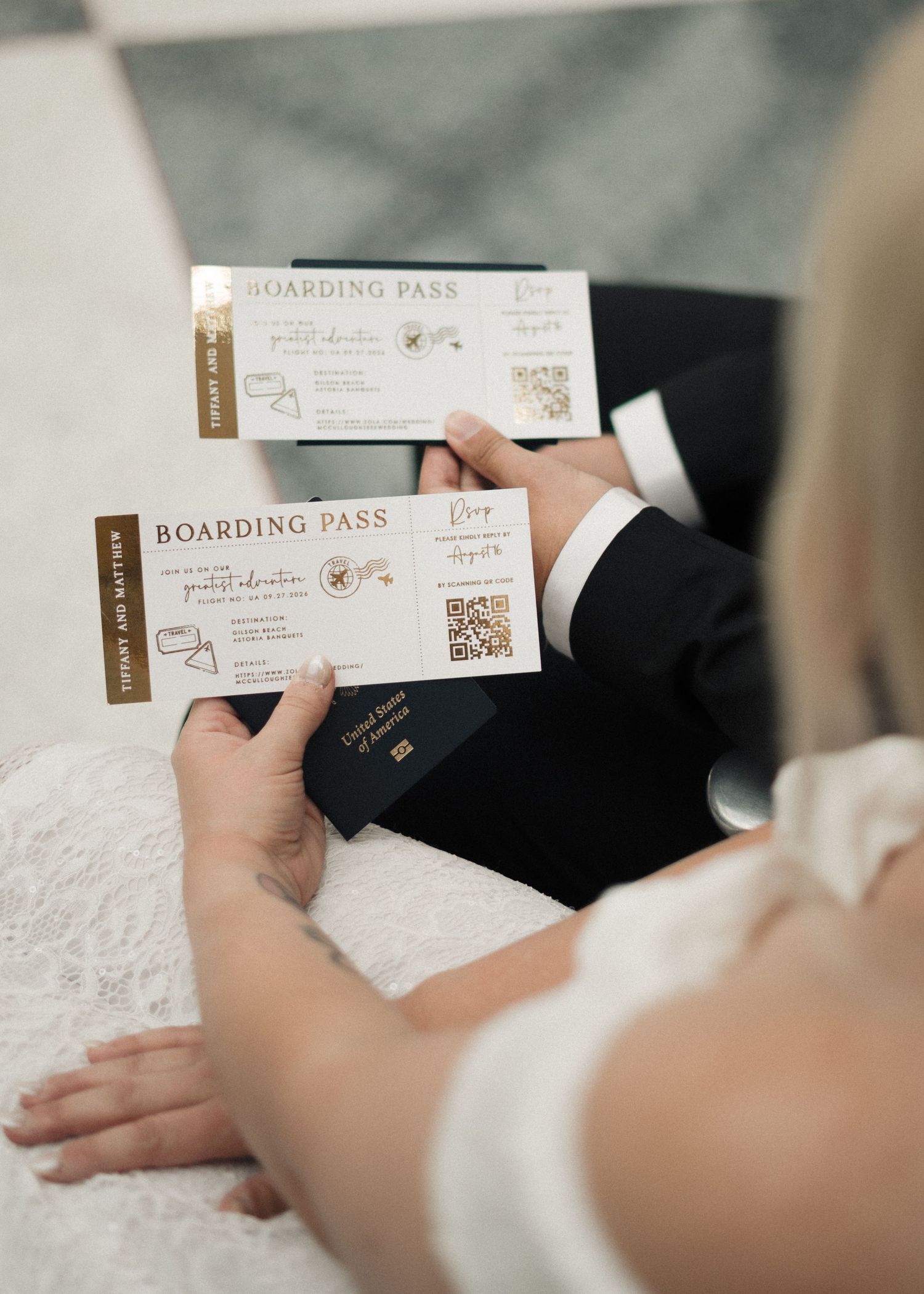 Bride and groom holding wedding boarding pass invitations with passport, travel themed wedding stationery.
