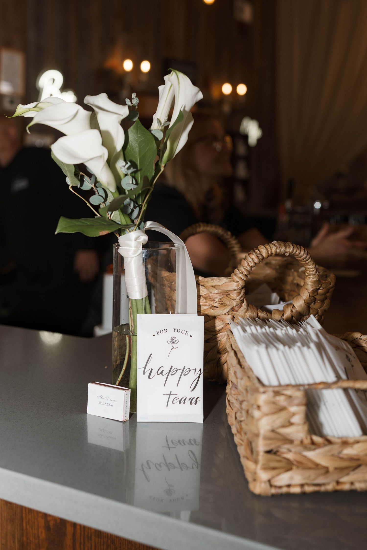 Wedding ceremony table display with white calla lilies and a happy tears sign with tissue basket.