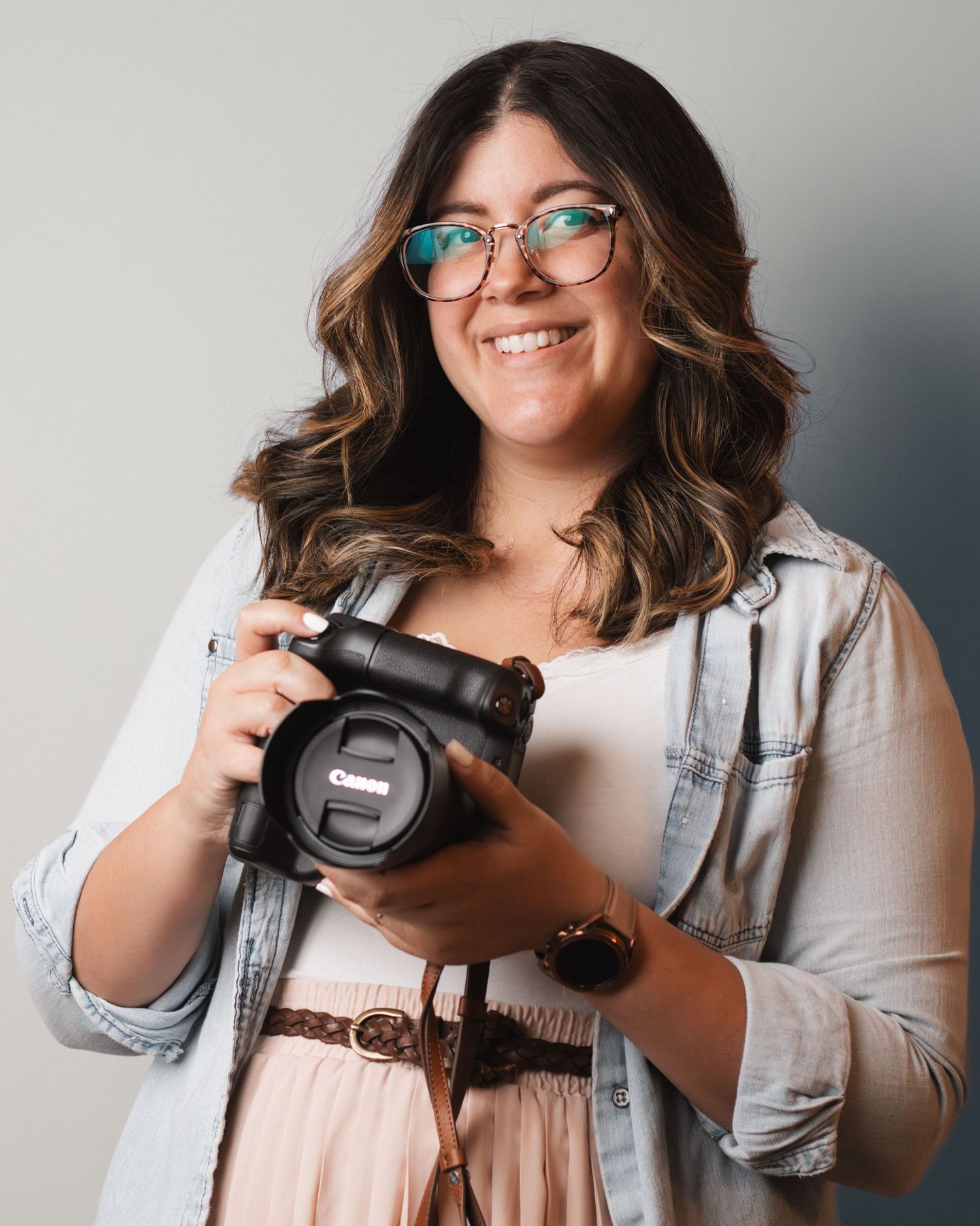 Orlando photographer smiling while holding her camera during a natural, professional headshot portrait.
