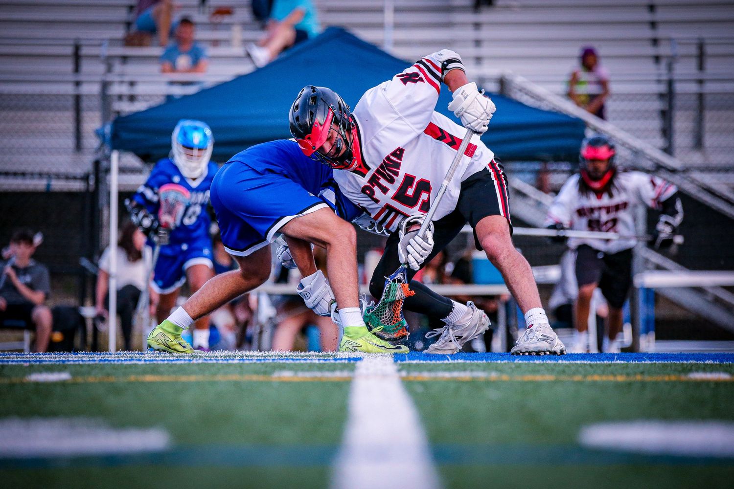 Boys varsity lacrosse players faceoff for the ball in Mercer County, New Jersey.