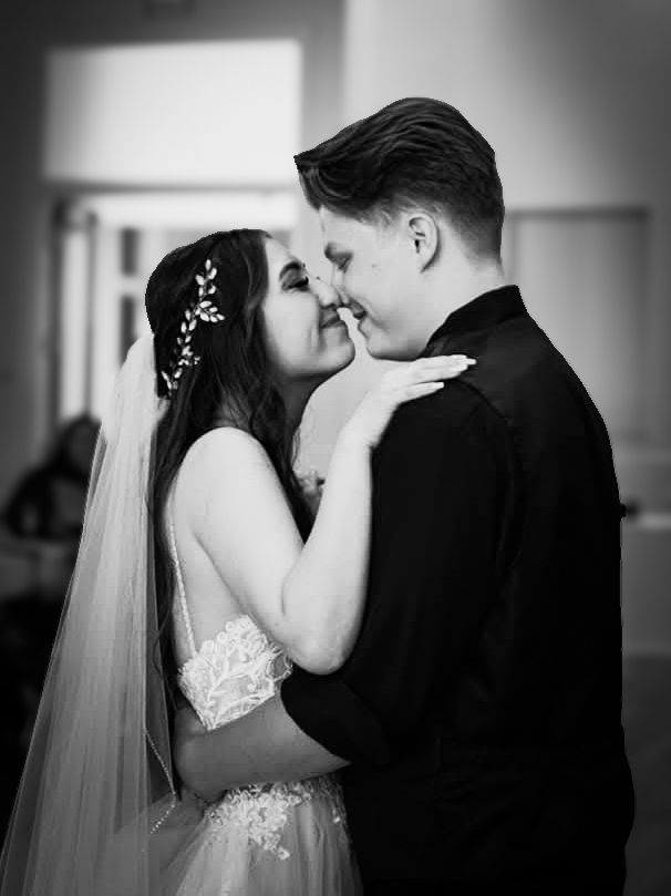 A bride and groom embracing and kissing on their wedding day.