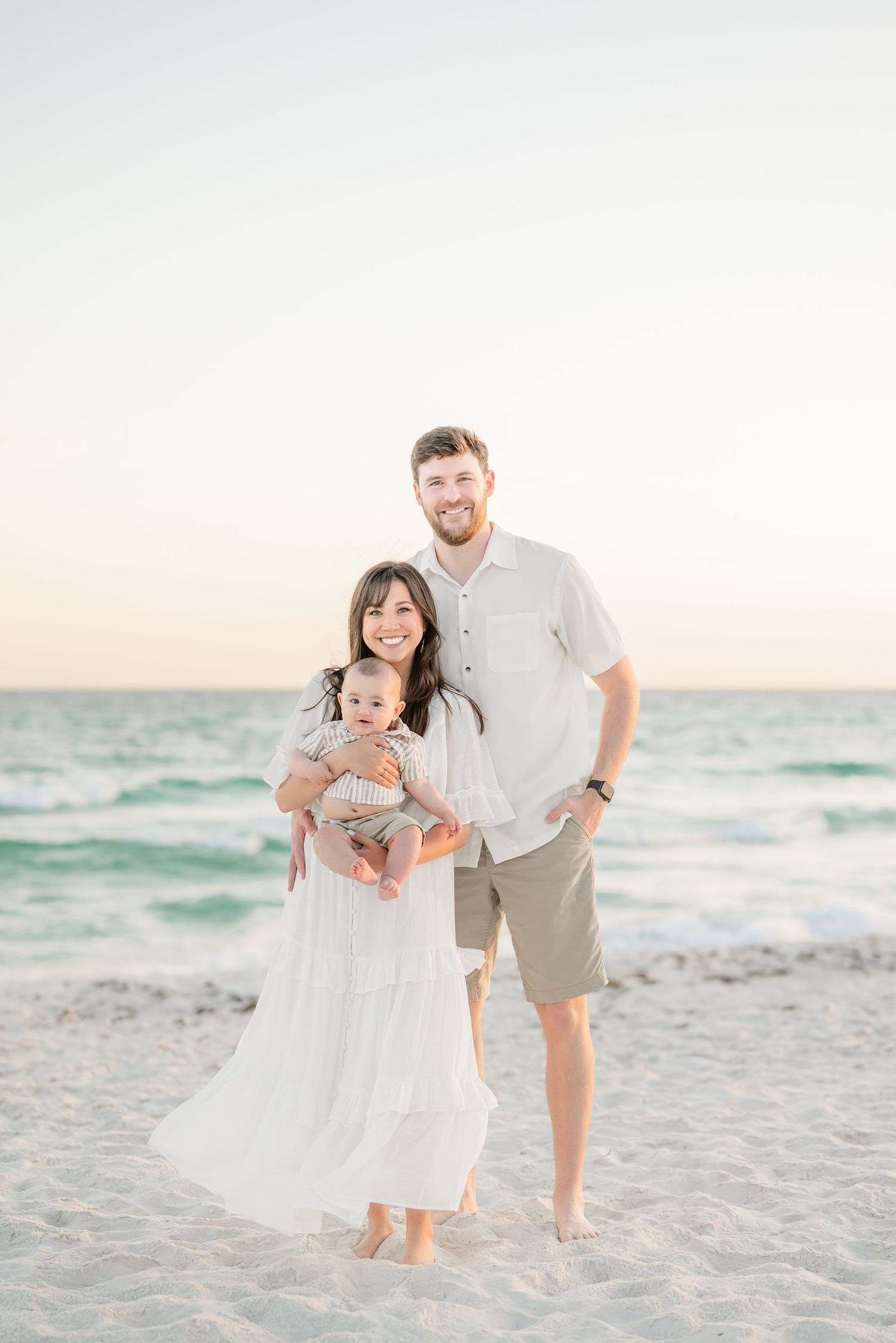 Beautiful family beach portraits at sunset with waves in the background.