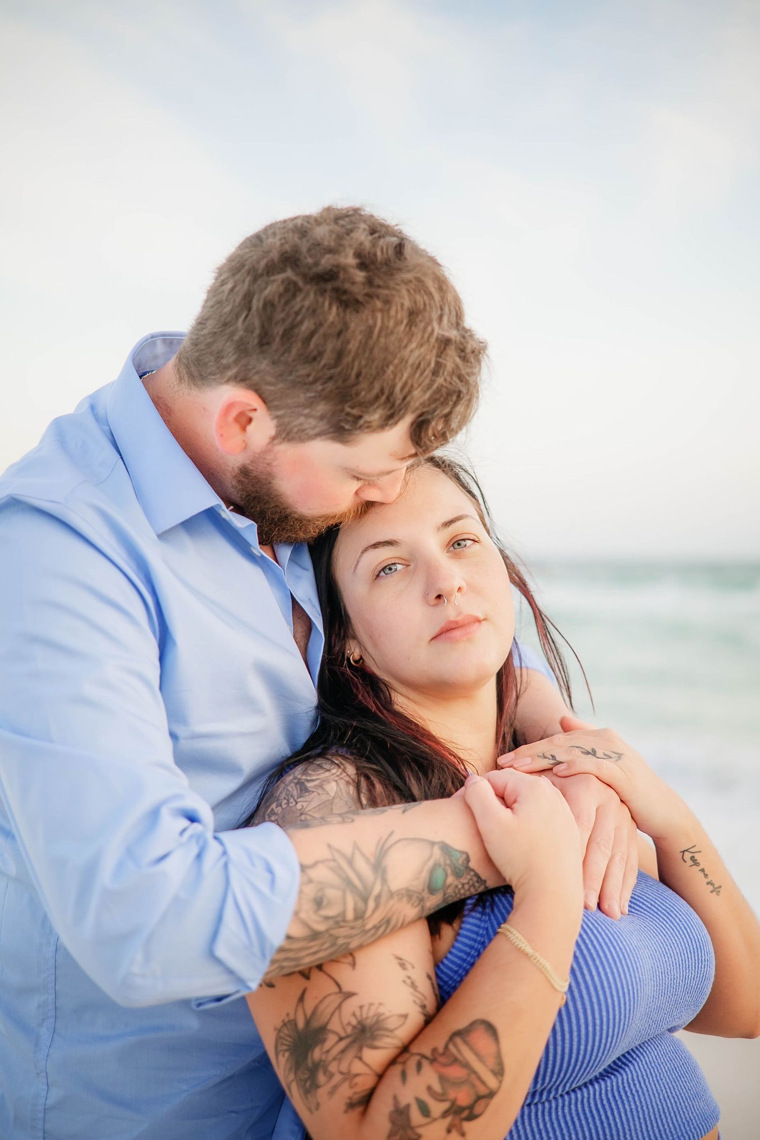 Intimate beachside portrait session with couple in blue and light colored clothing.
