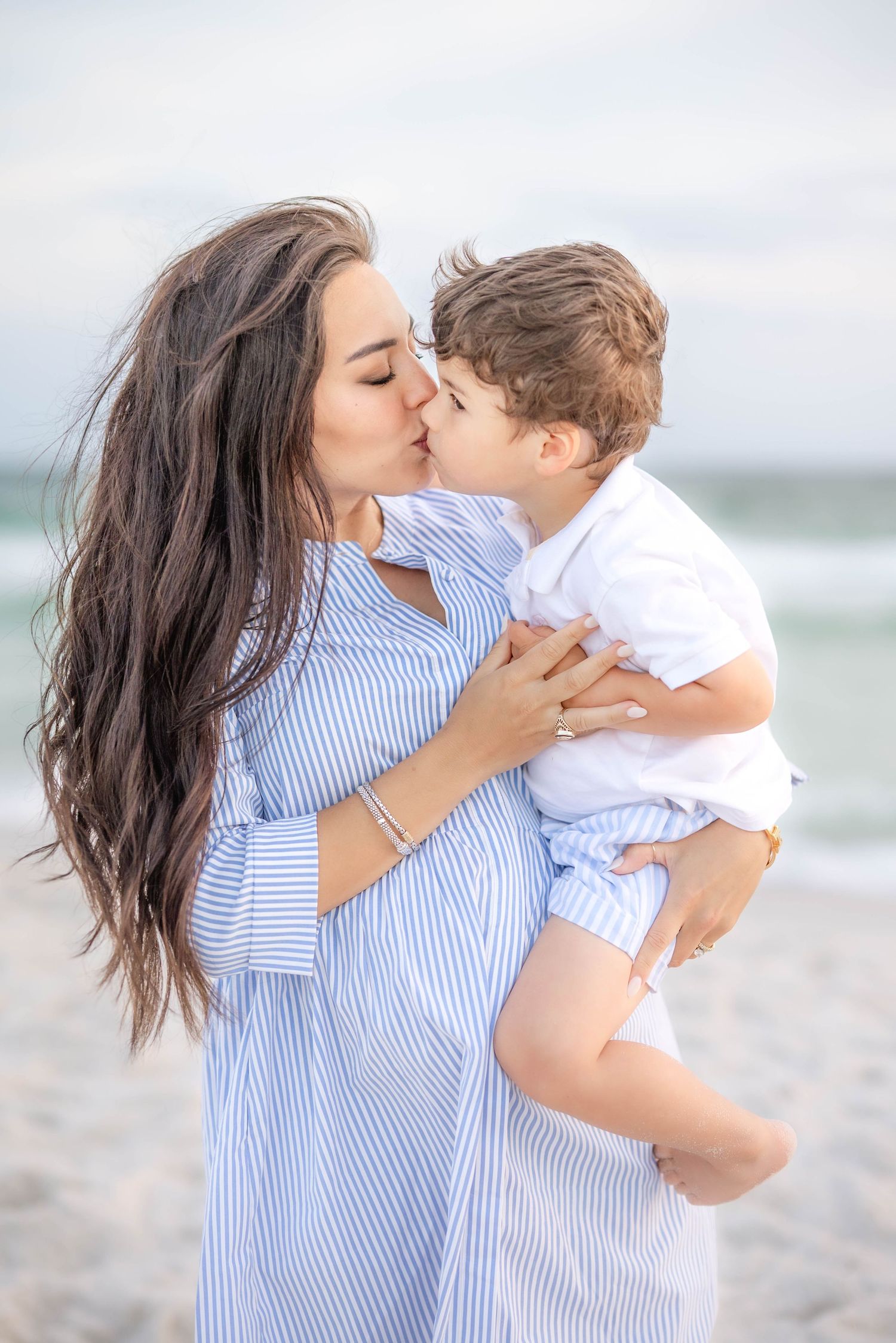 Tender moment between parent and child on a sunny beach.