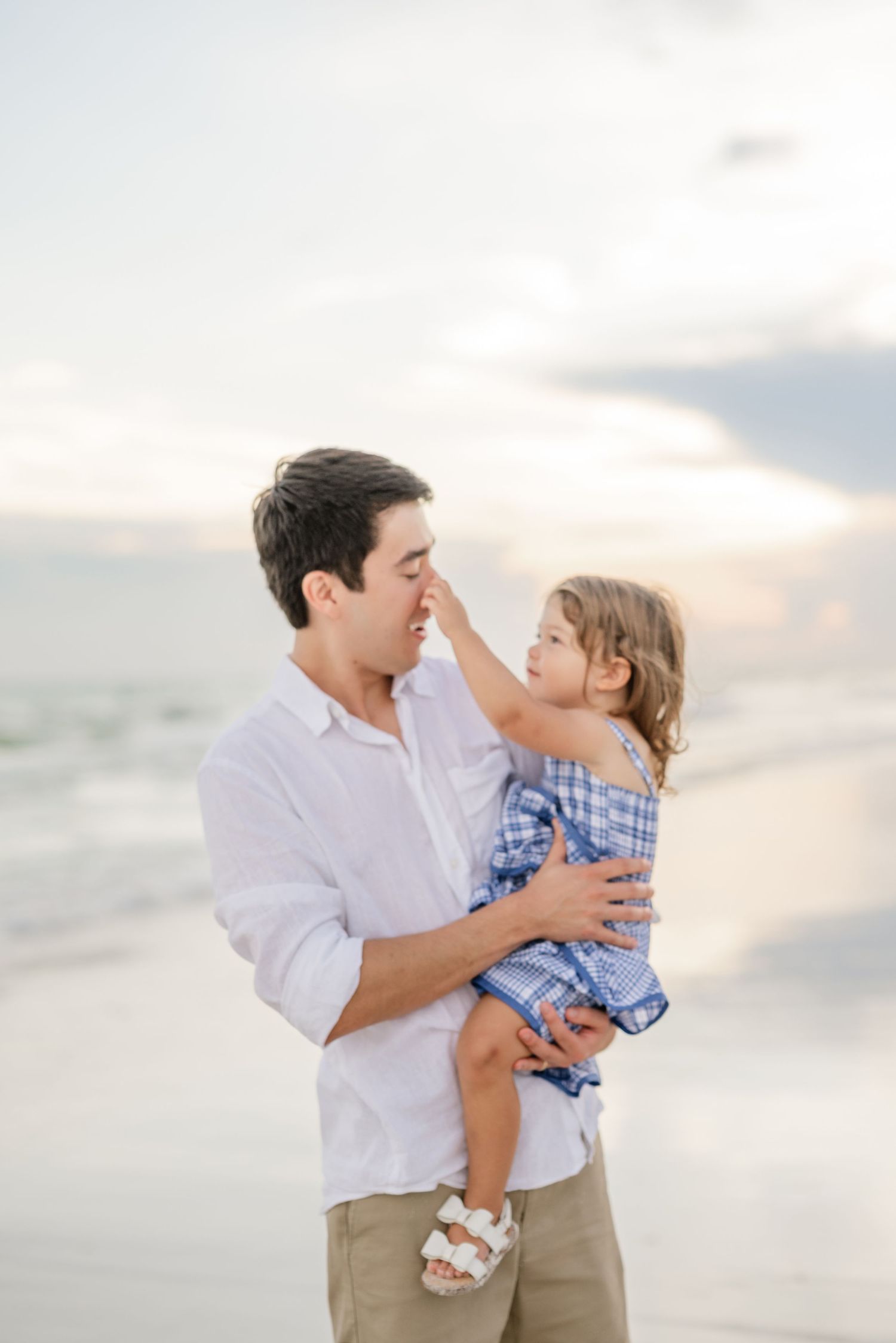Playful family interactions captured on beach during golden hour.