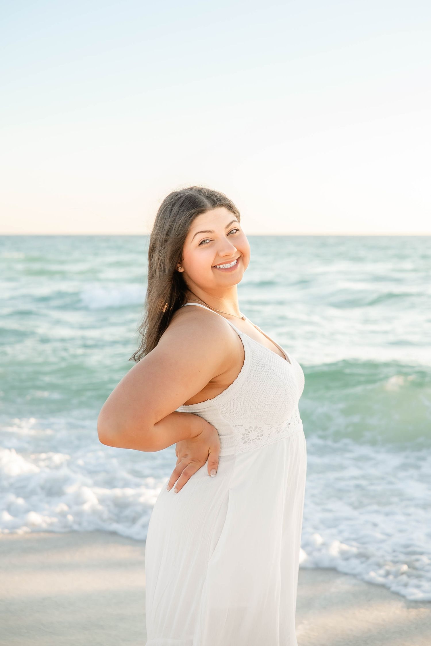 Bright and airy beach portraits with gentle waves and soft natural lighting.