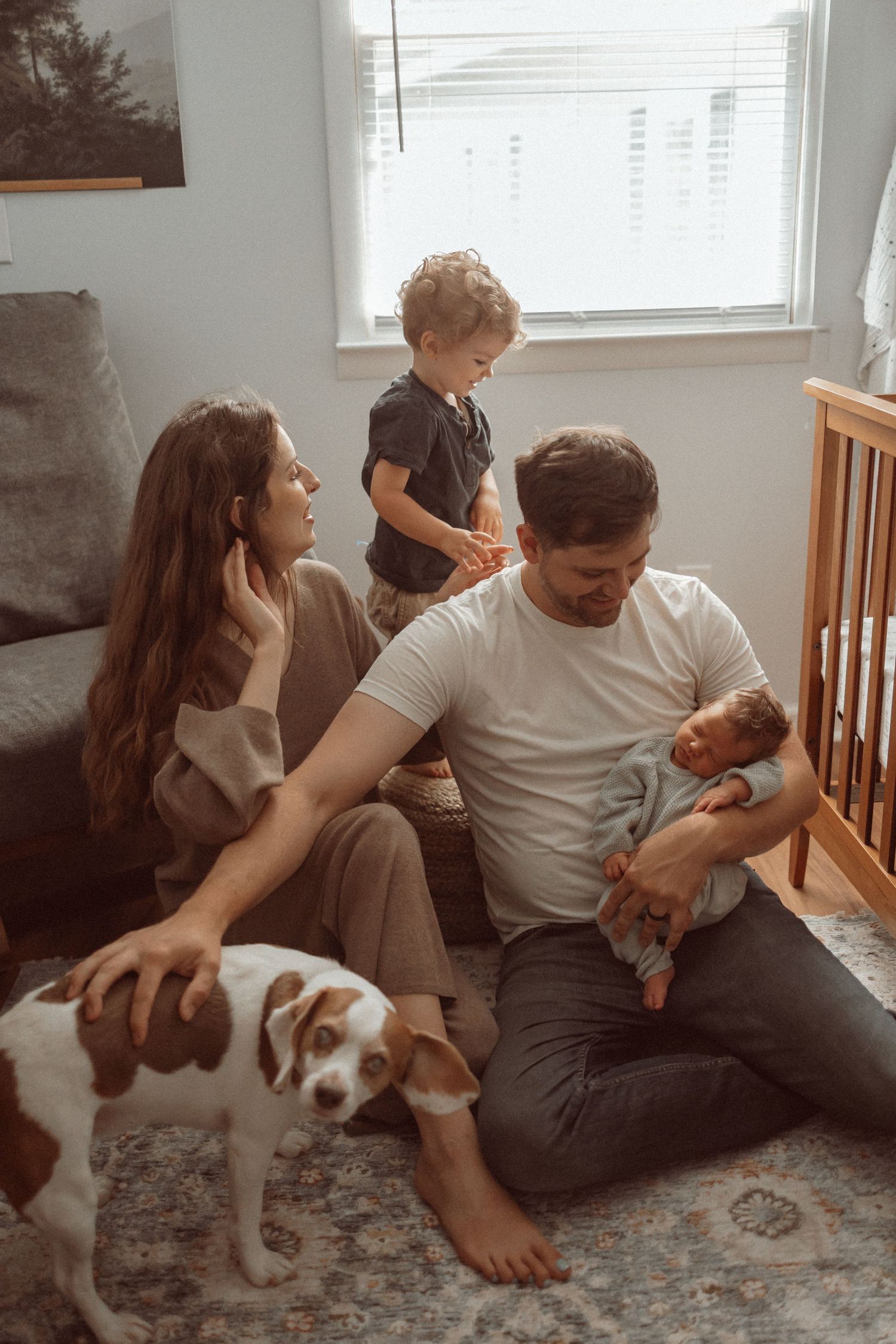 Cozy family scene at home with a dog and baby in a warmly lit room.