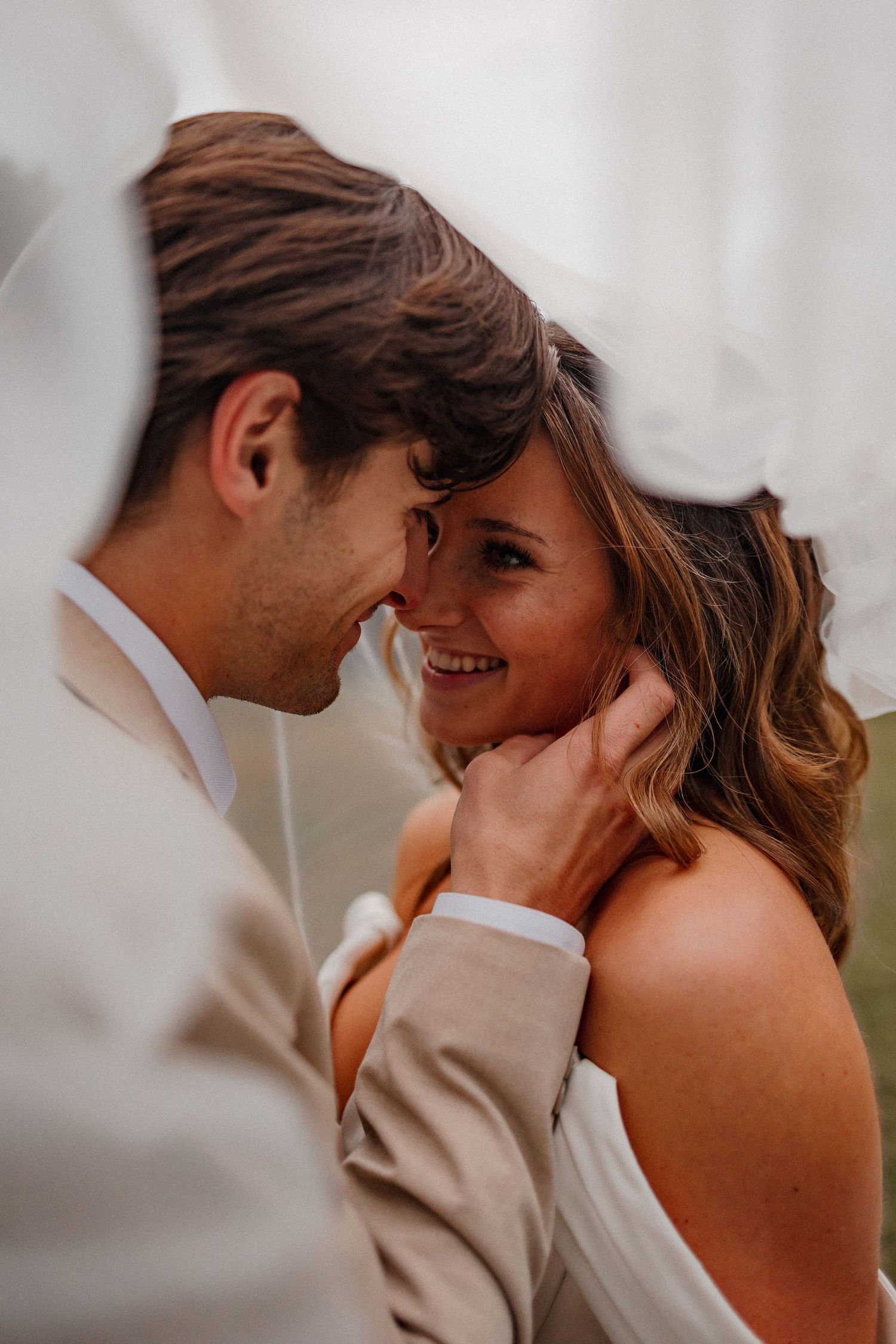 Intimate close-up of couple sharing tender moment against white background.