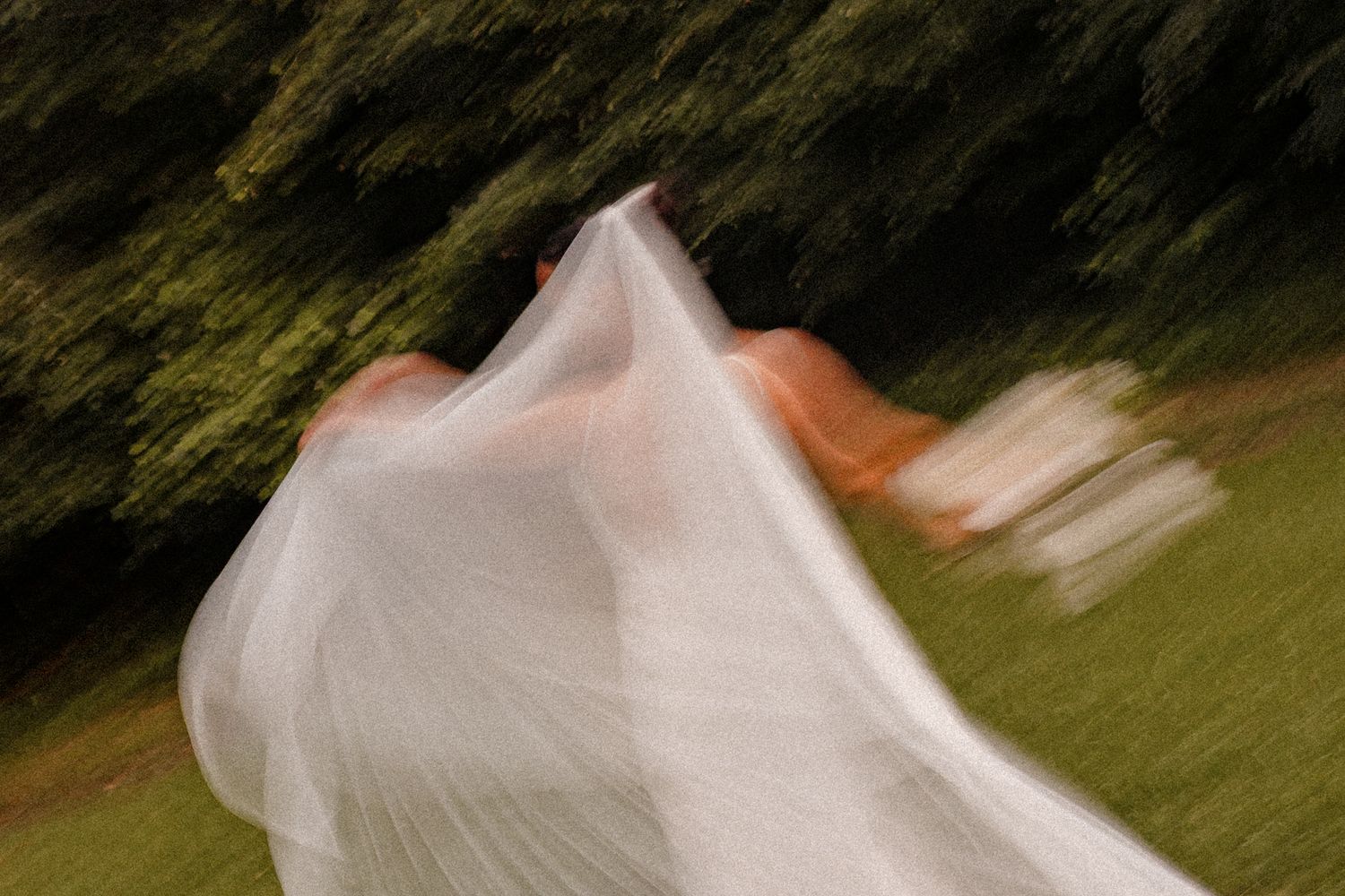 Flowing white wedding dress twirling in an outdoor setting.