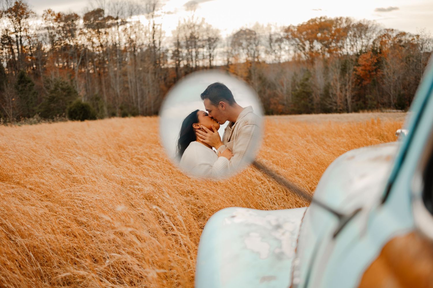 Intimate moment captured through car window in autumn field setting.