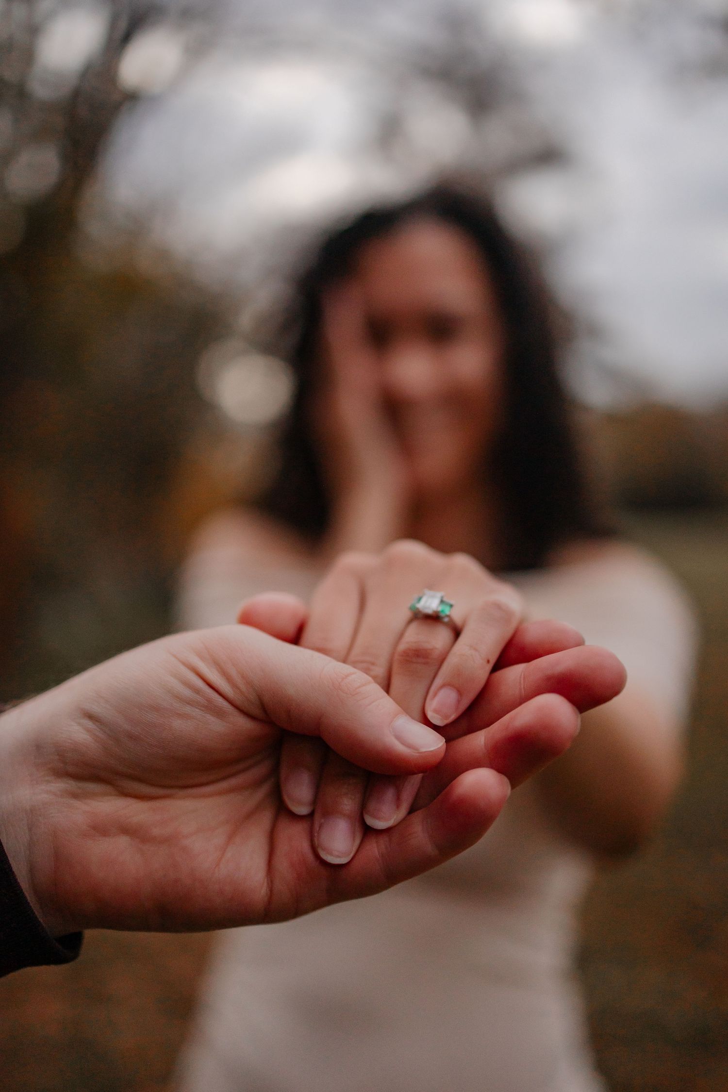 A girl with your hand up close showing off her engagement ring