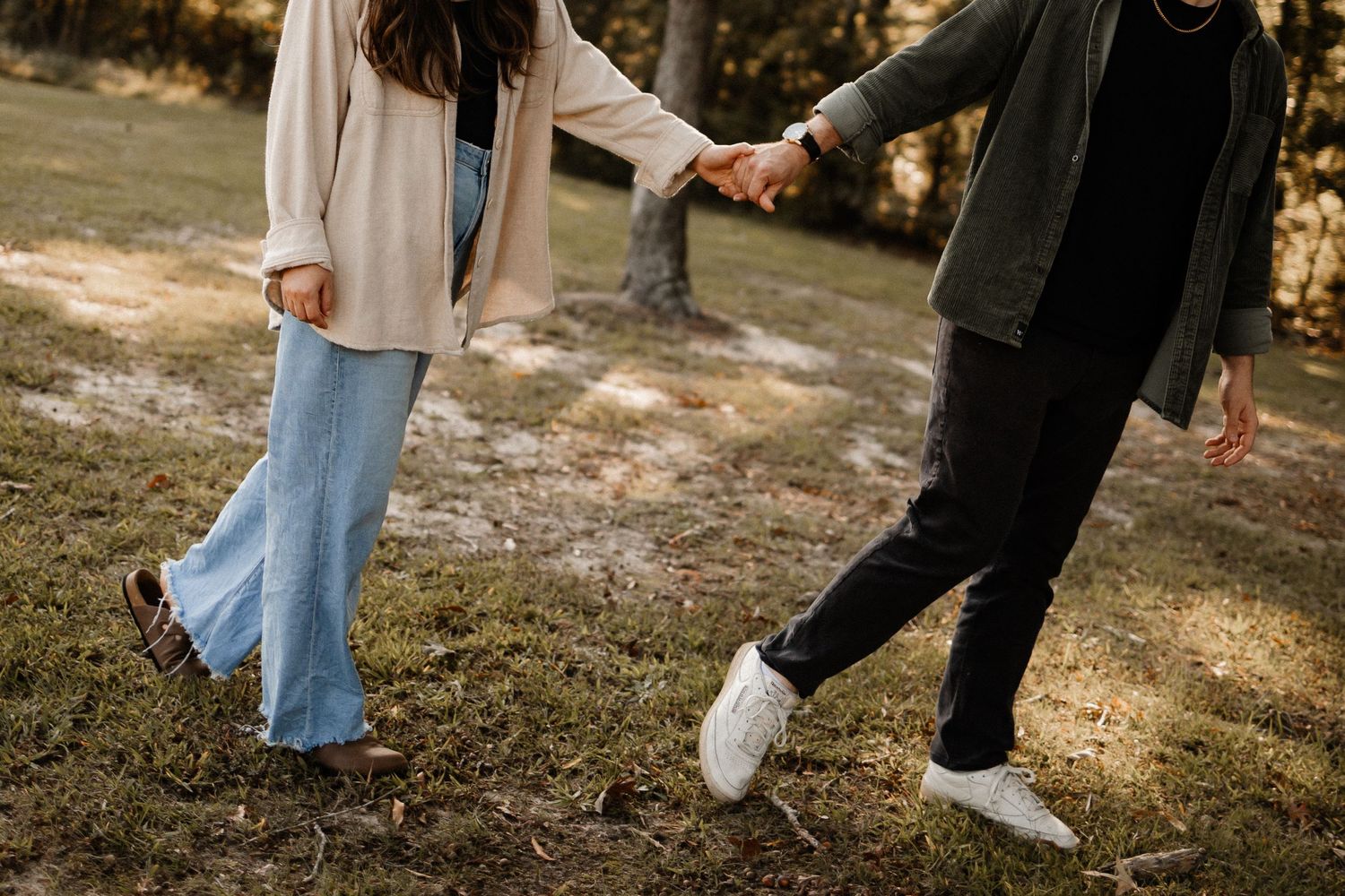 A couple holding hands walking at an angle