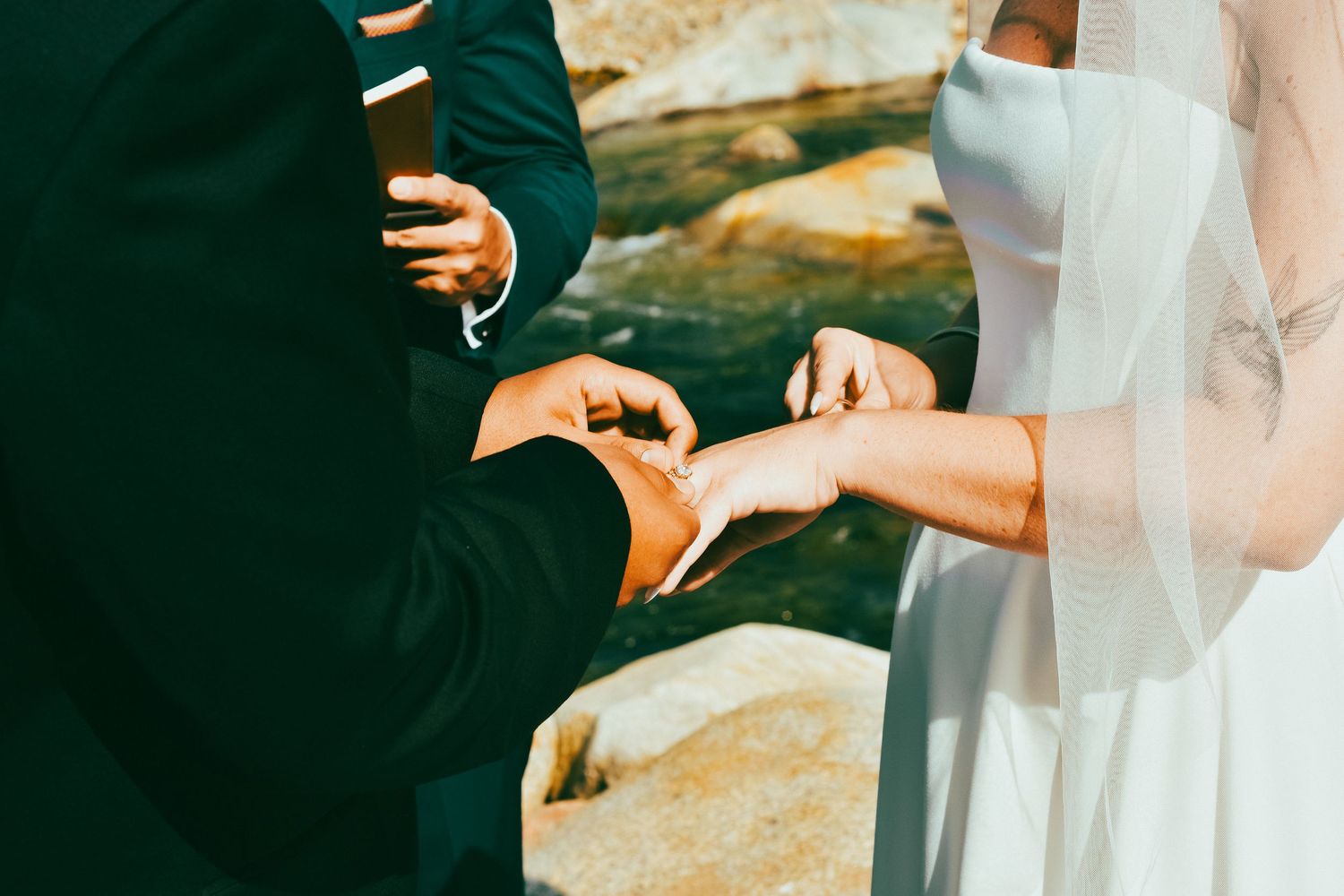 A couple in front of a Sequoia Forest River exchanges rings for their small wedding