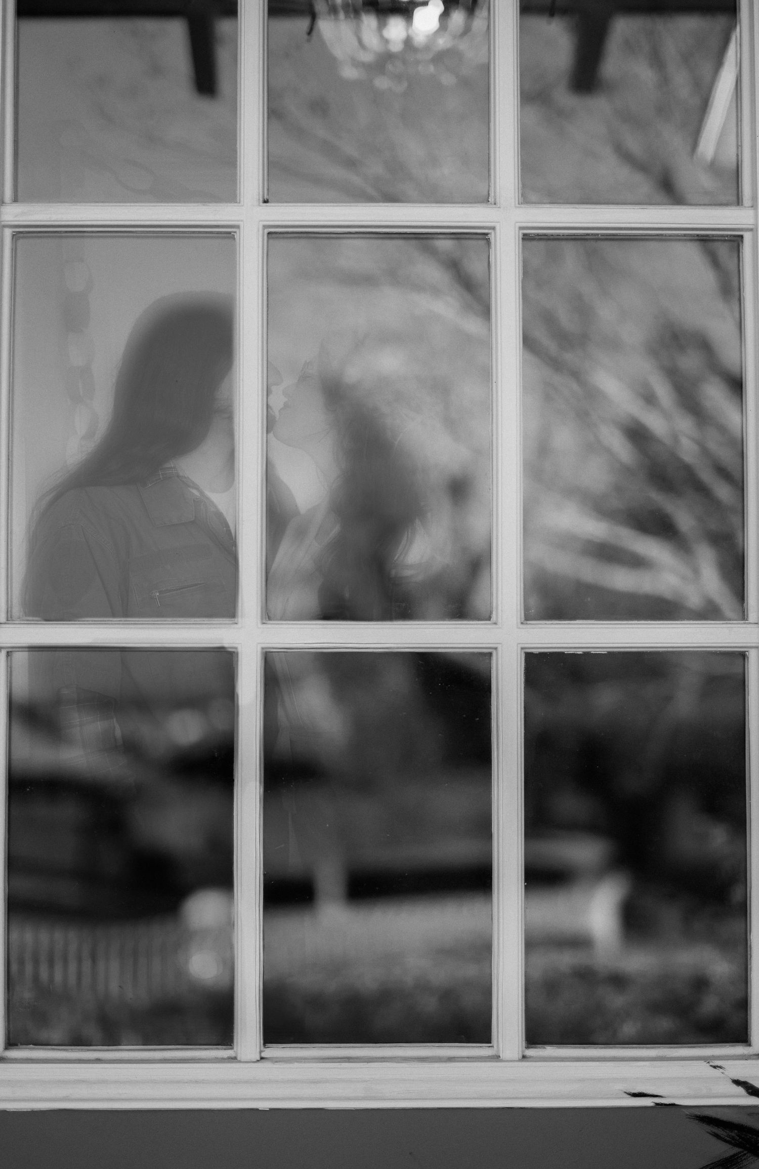 /a couple is seen through a window in a vintage retro photo shoot