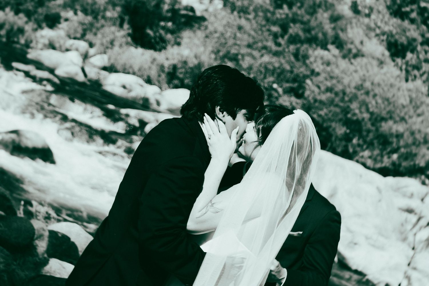 A newly married couple in a Sequoia Forest River almost kiss