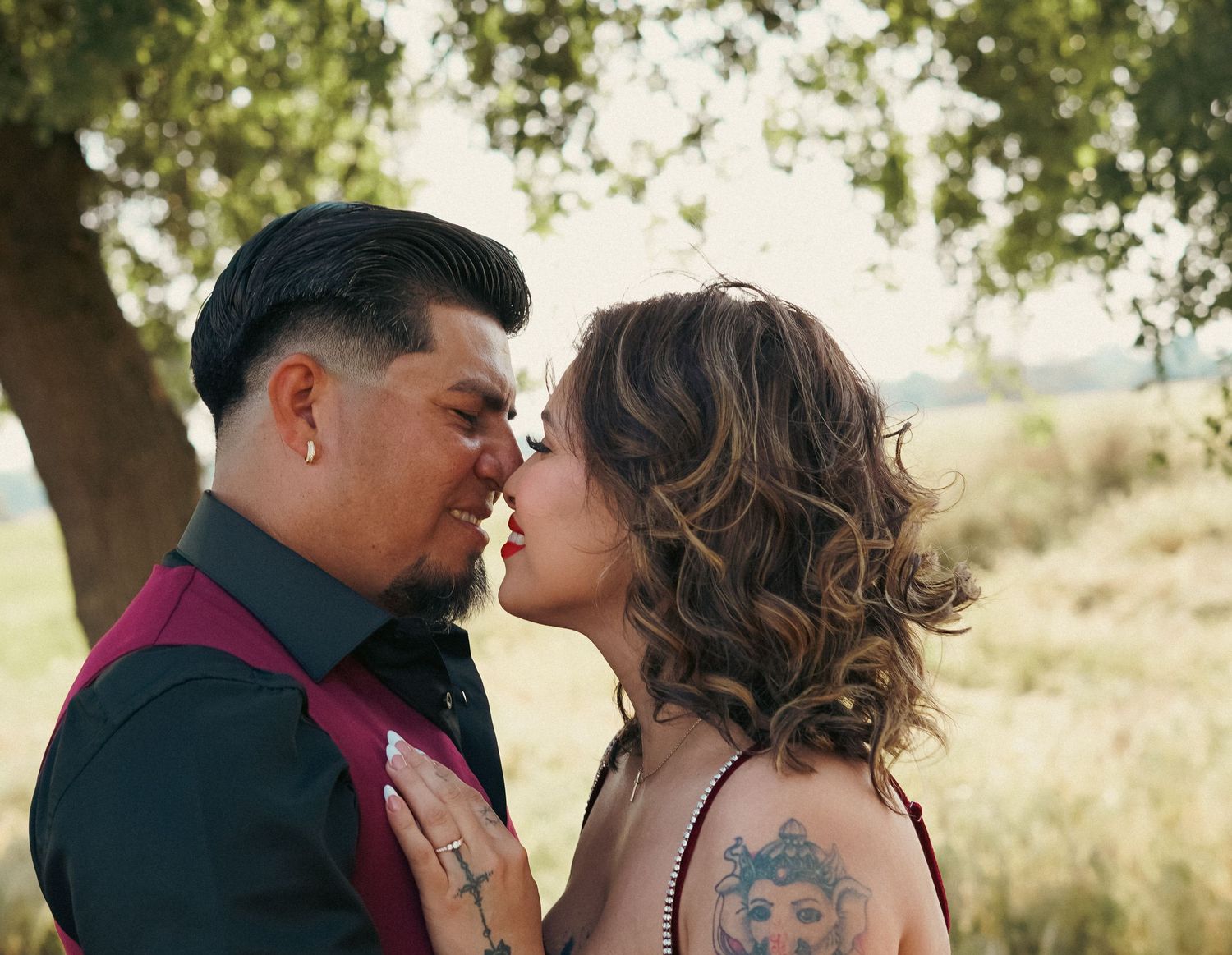 A couple in Exeter California pose for engagement photos. The woman rest her hand on his chest