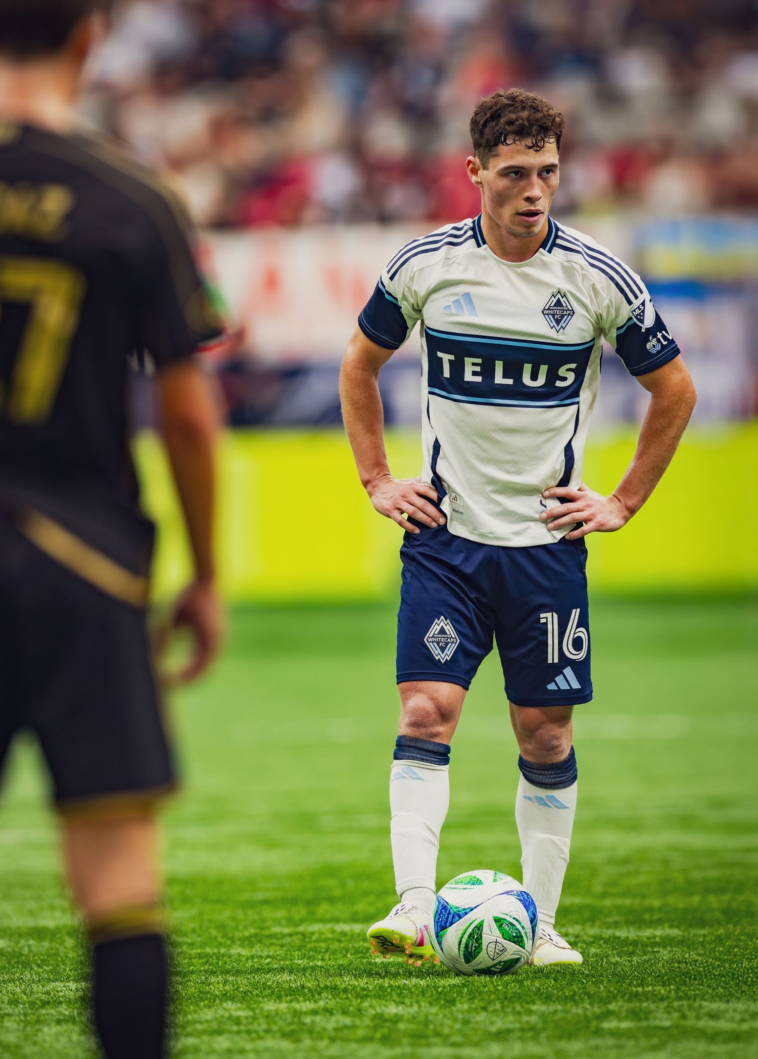 Vancouver Whitecaps player number 16 in TELUS jersey preparing for free kick during MLS game.