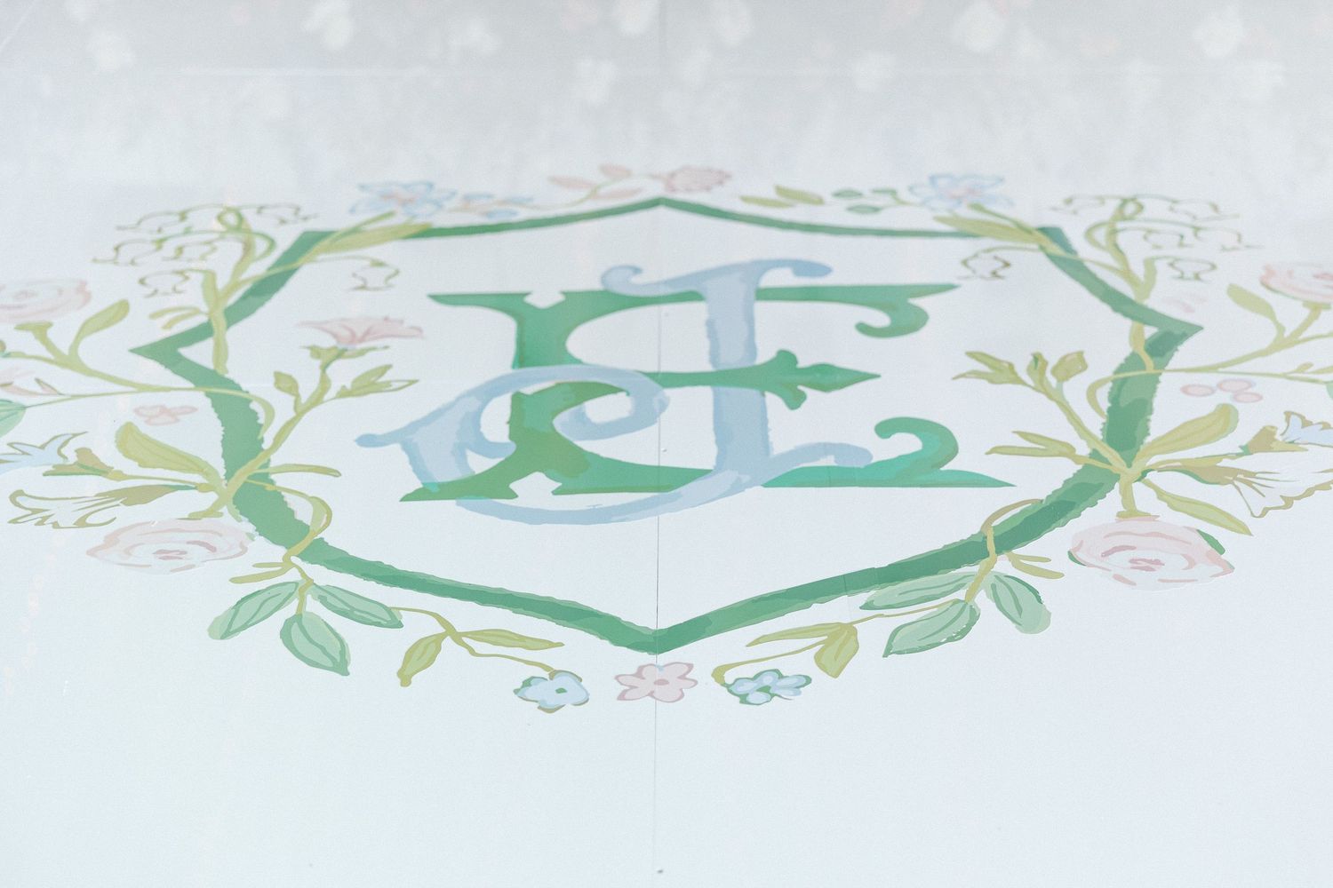 Decorative green floral border pattern with delicate leaves and vines in a repeating design.