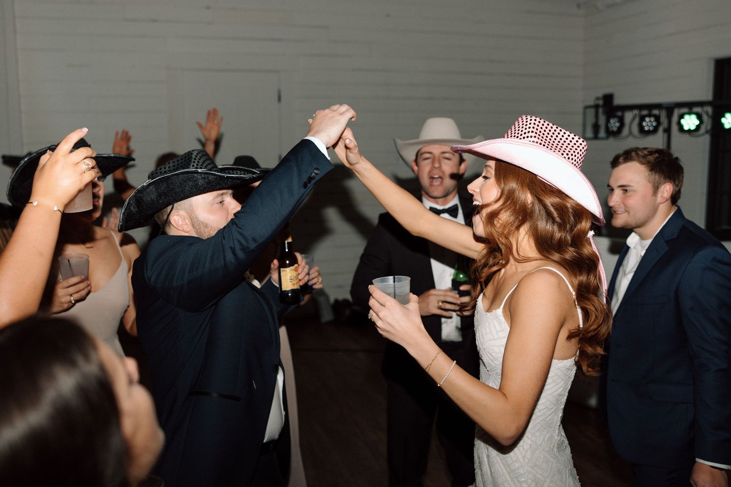 Wedding guests dance and celebrate on the dance floor during a lively reception party.