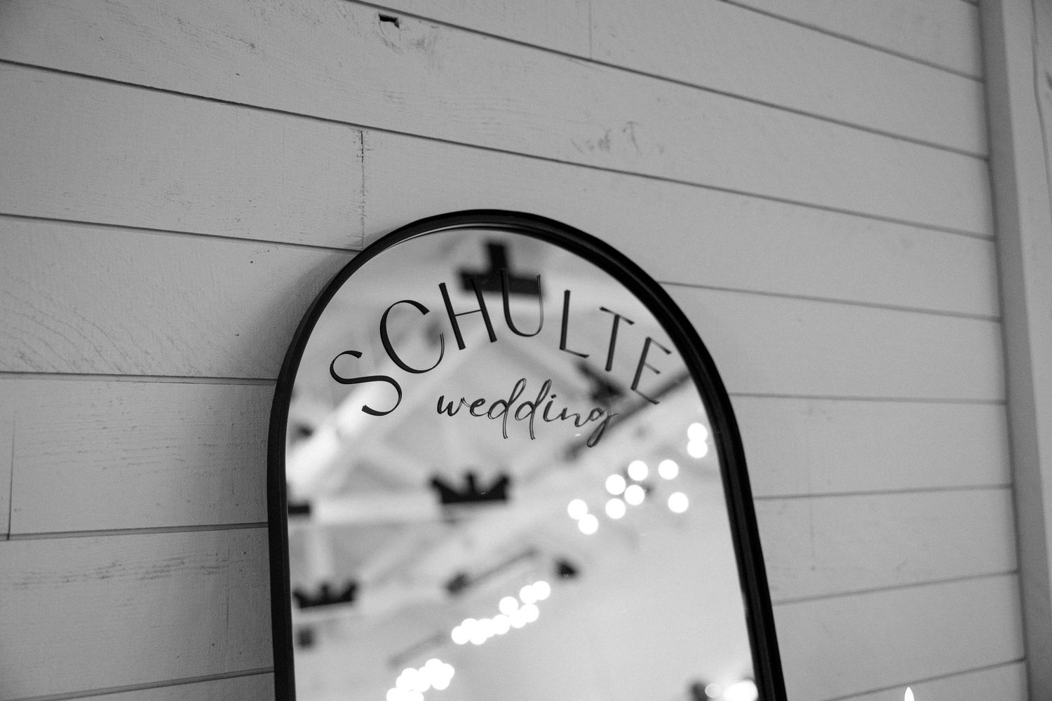 A row of decorative circular mirrors with text and designs hang on a white wooden wall.