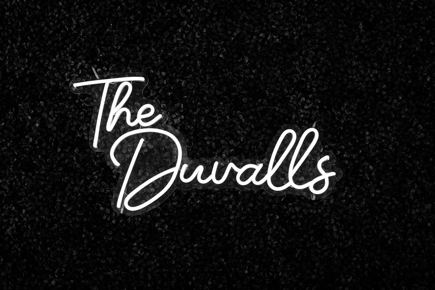 A handwritten cursive text reading 'The Duvall's' in white neon style against a dark background.