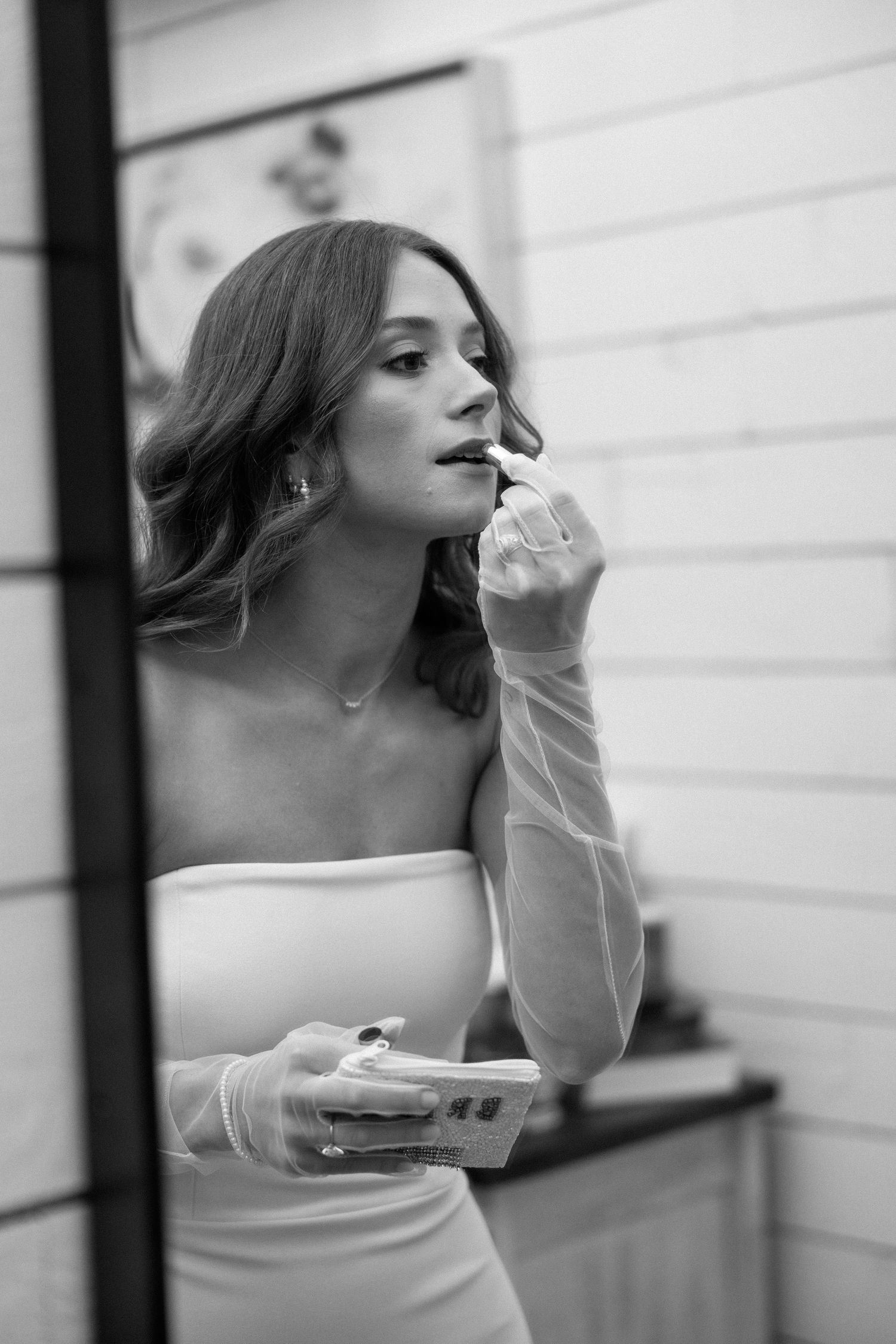 A series of four black and white photos showing a person in a strapless dress taking a bite of food.