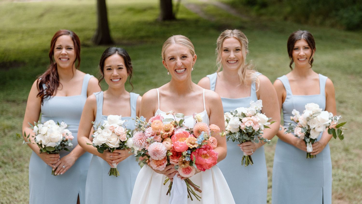 A panoramic collage of bridesmaids in light blue dresses holding white and coral floral bouquets outdoors.