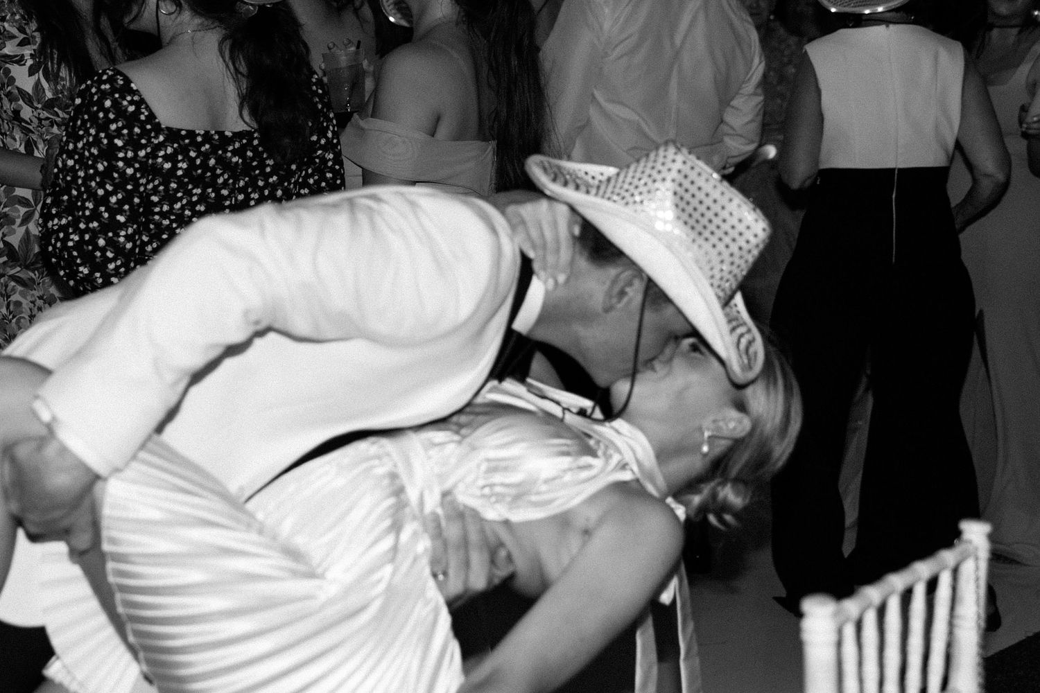 A series of black and white party photos showing people dancing and celebrating at a festive event.