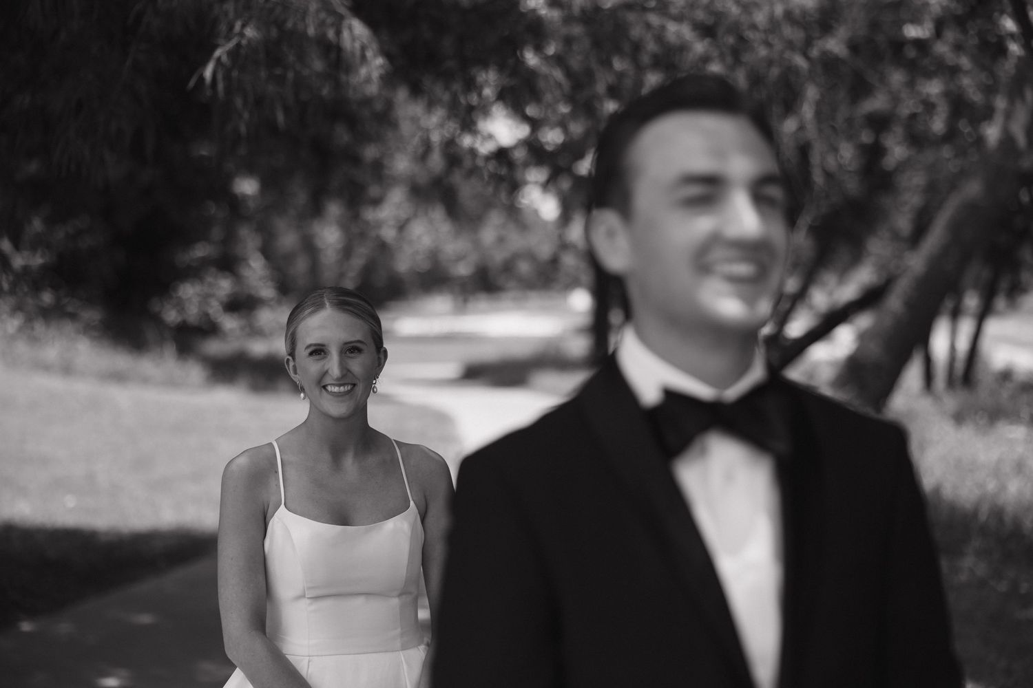 A wedding couple shares intimate moments in black and white photos during their outdoor celebration.