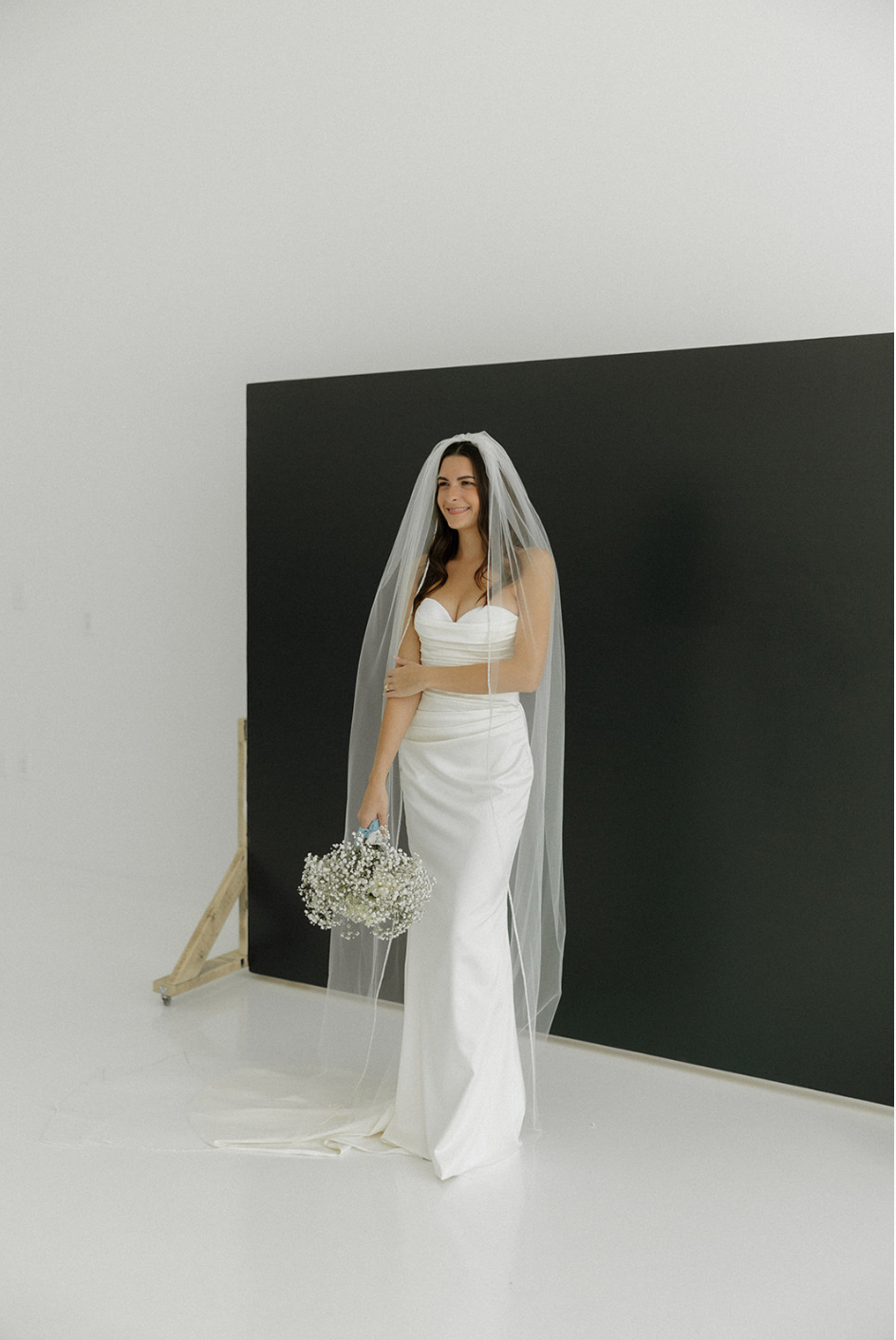 Elegant bridal portraits in white dress and veil against minimalist studio backdrop.