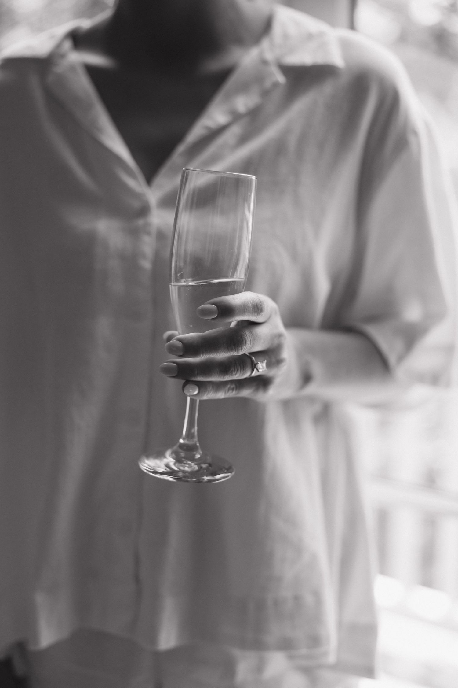 Black and white sequence showing hands holding a champagne glass in elegant motion.