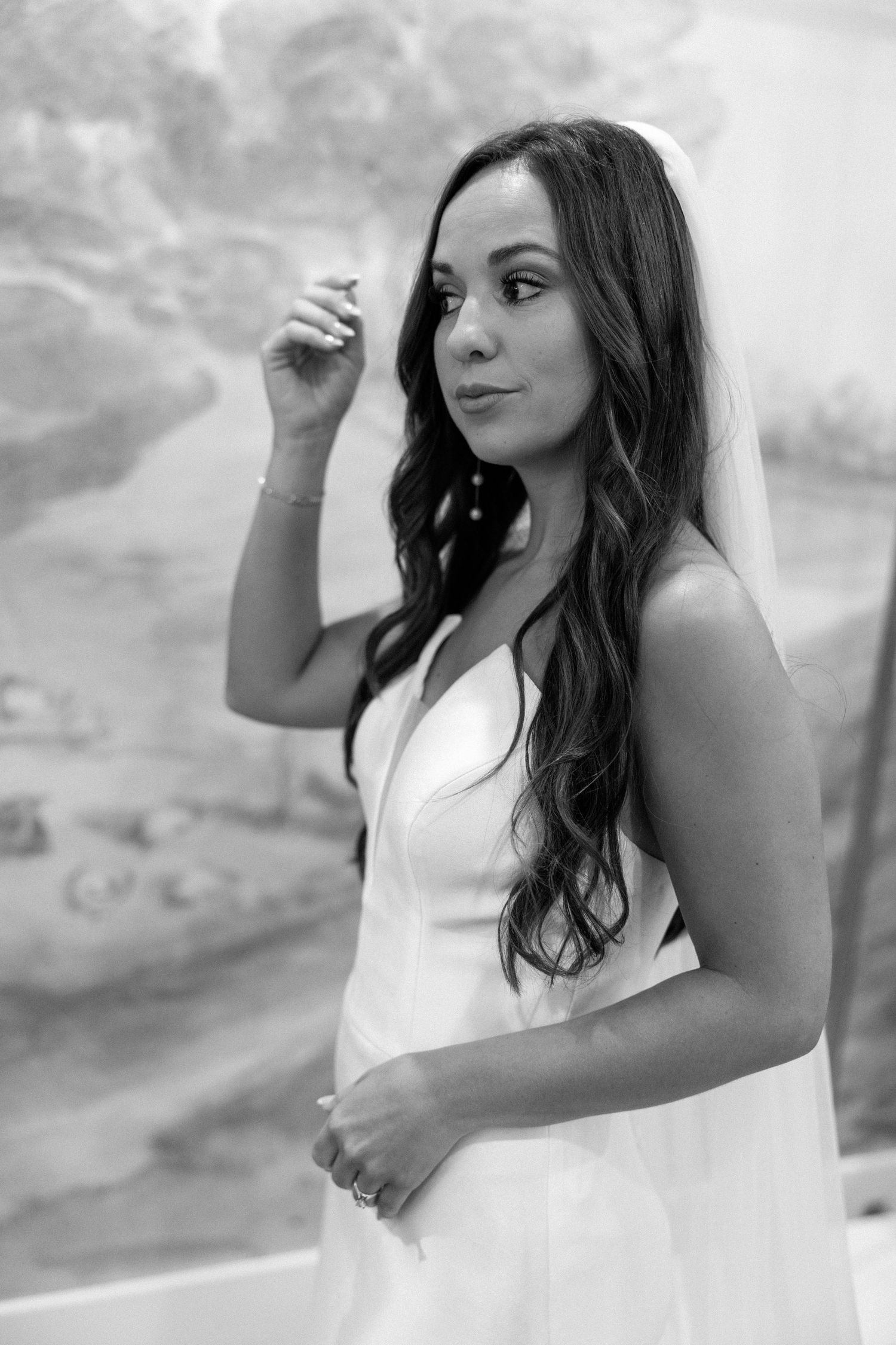 Black and white photo series showing a woman in a white dress posing against a cloudy backdrop.