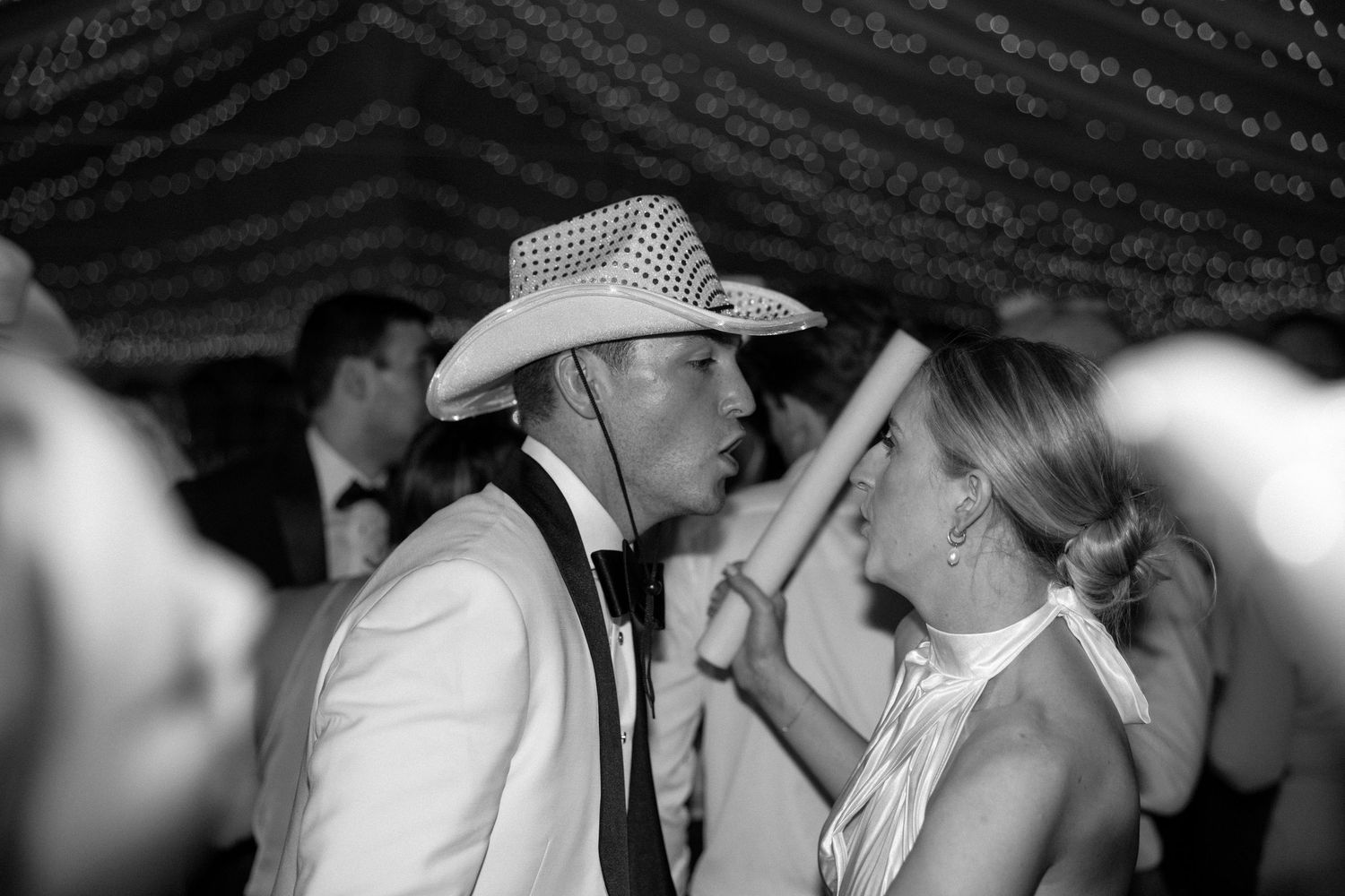 Black and white photo showing people dancing together at a country western event.