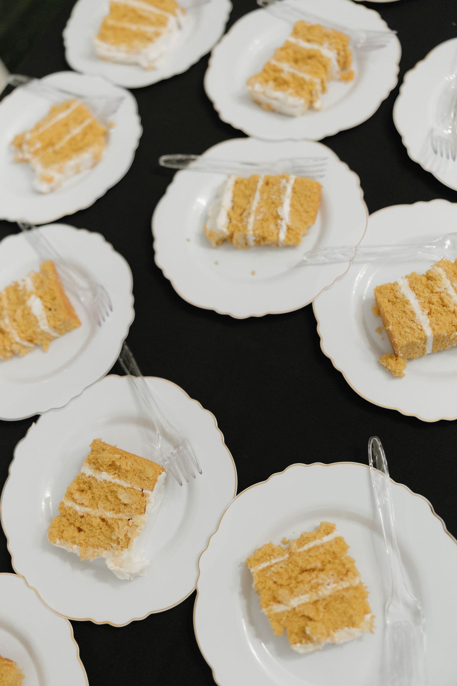 White meringue cookies topped with golden graham cracker pieces arranged on a dark surface.