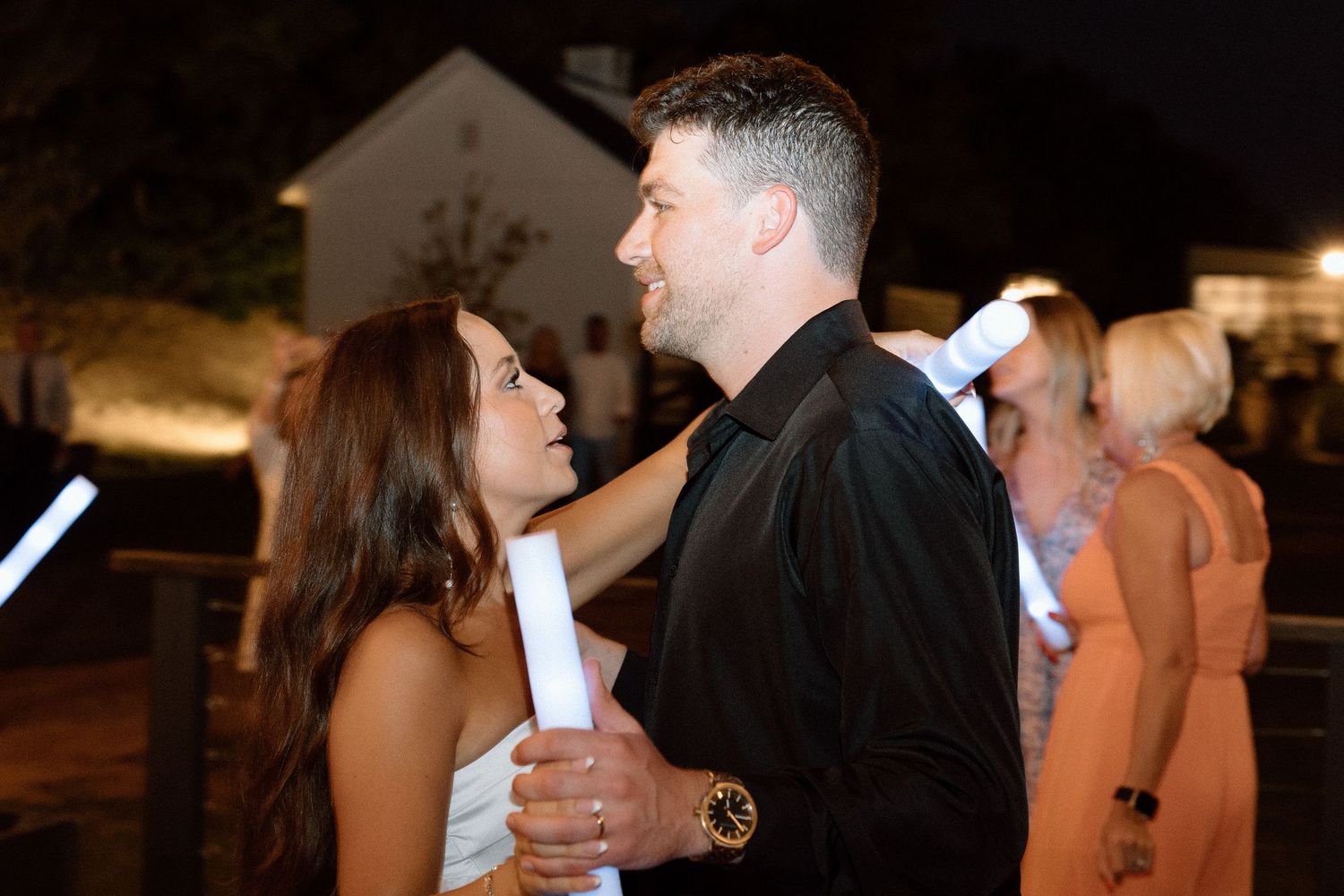 Couples share intimate dance moves on a dimly lit dance floor during an evening celebration.