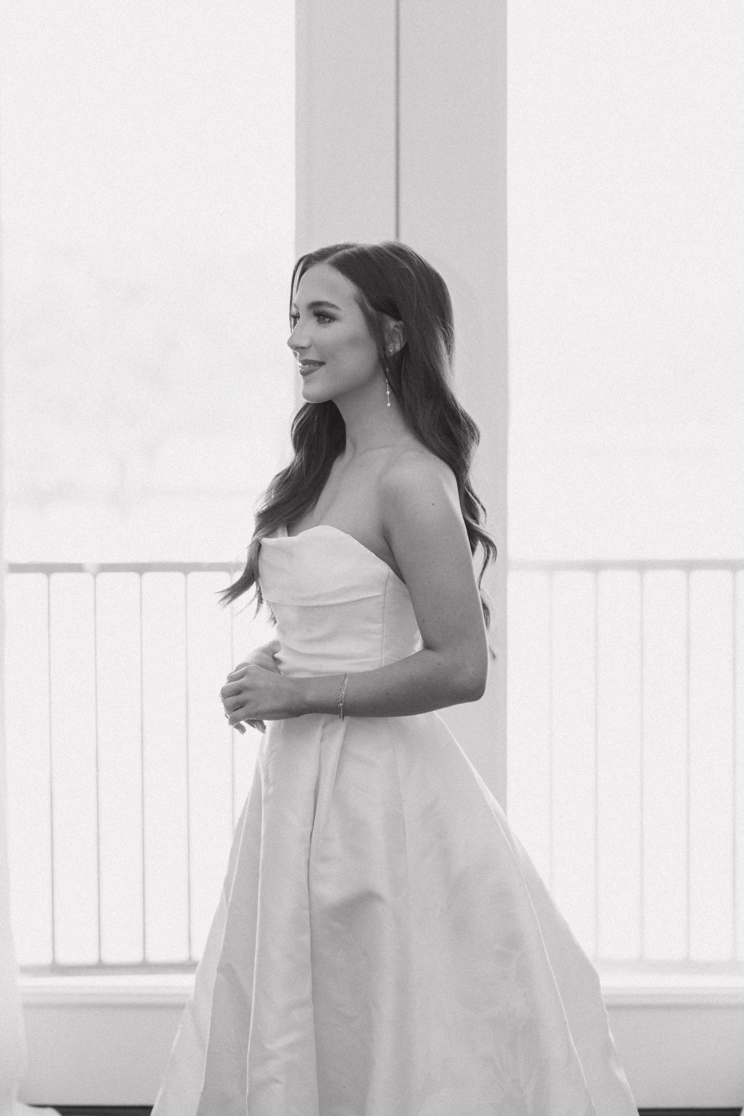 Elegant white strapless dress photographed in a series of artistic black and white portraits against a bright window.