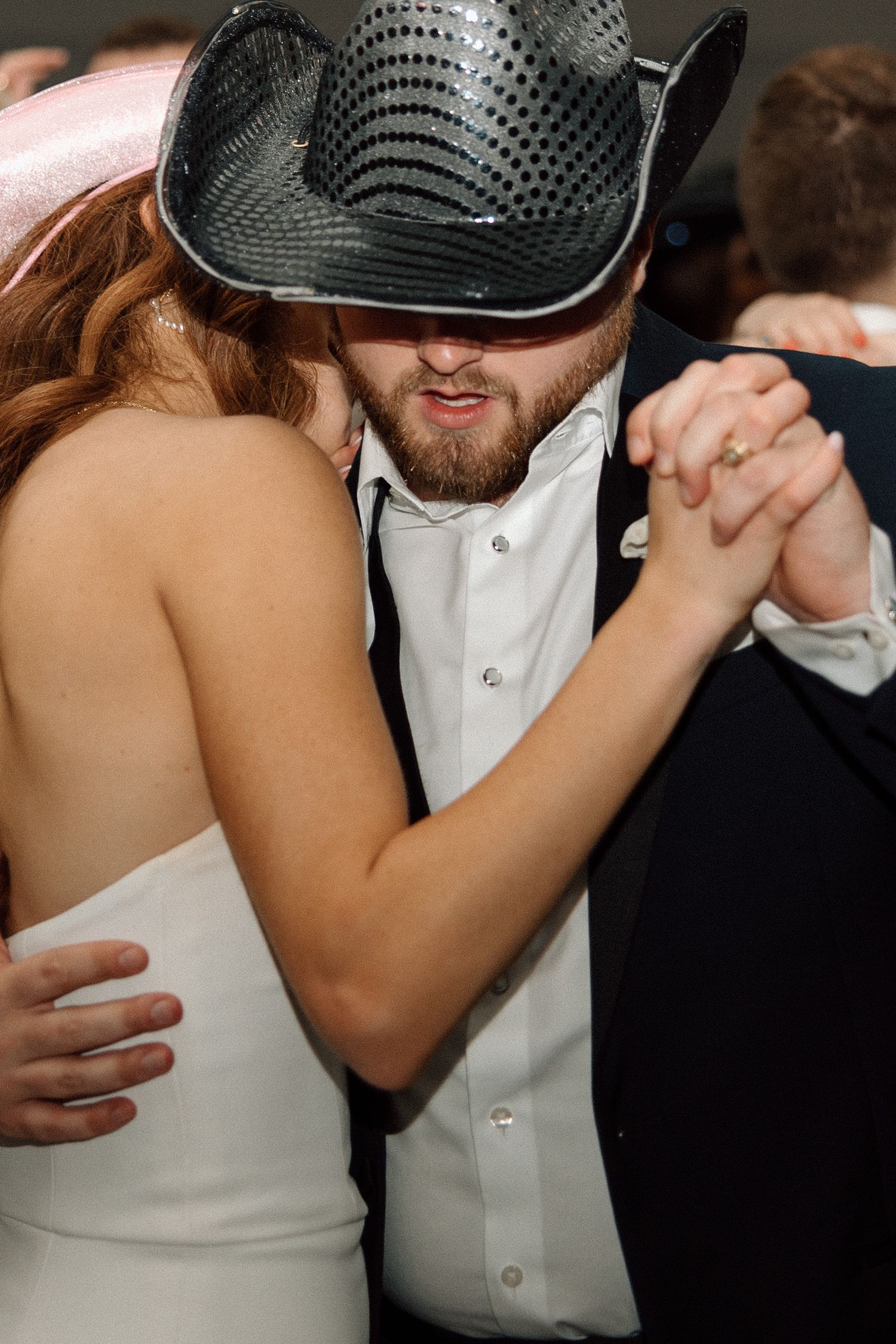 A romantic dance sequence showing a couple in formal attire embracing during a wedding celebration.