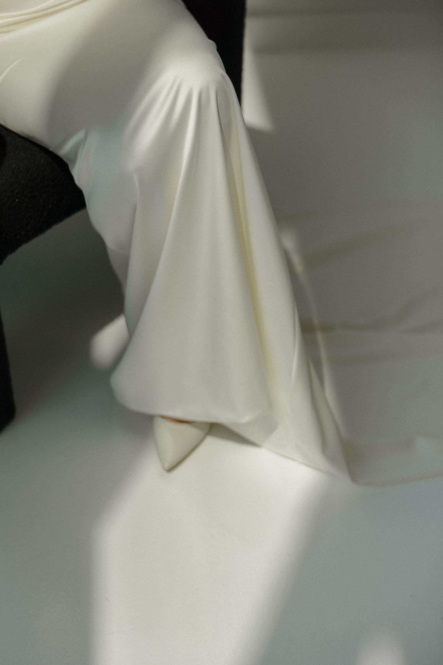 Abstract close-up shots of flowing white wedding dress fabric with dramatic shadows.