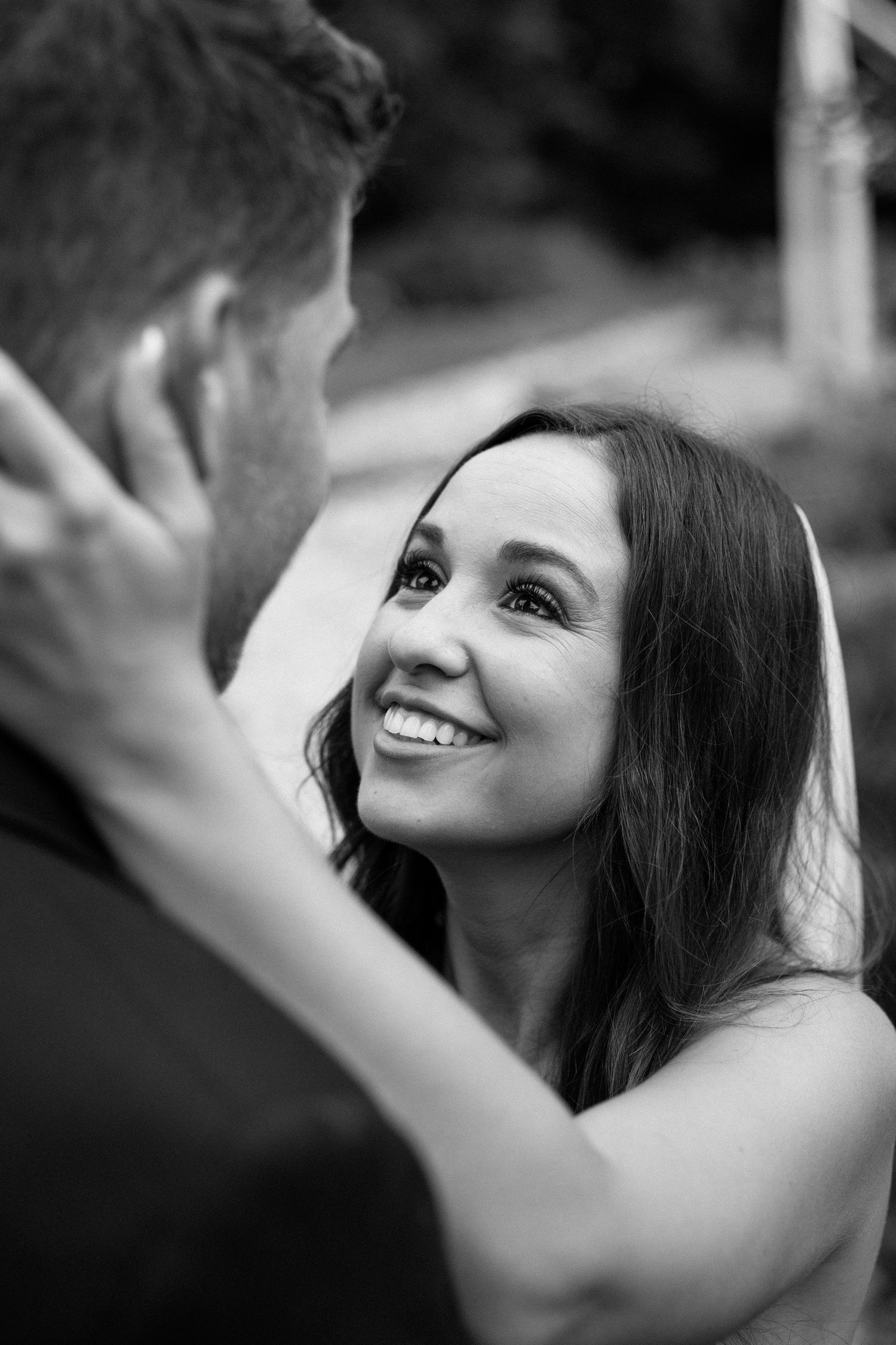 Black and white portrait sequence showing a woman with long dark hair smiling and looking upward with joy.