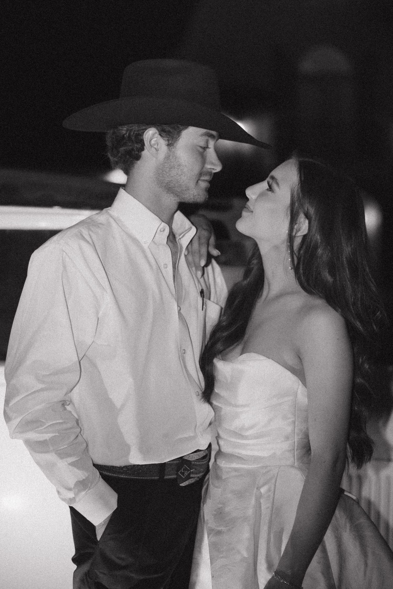 A romantic black and white photo series showing a couple in western attire sharing intimate moments.